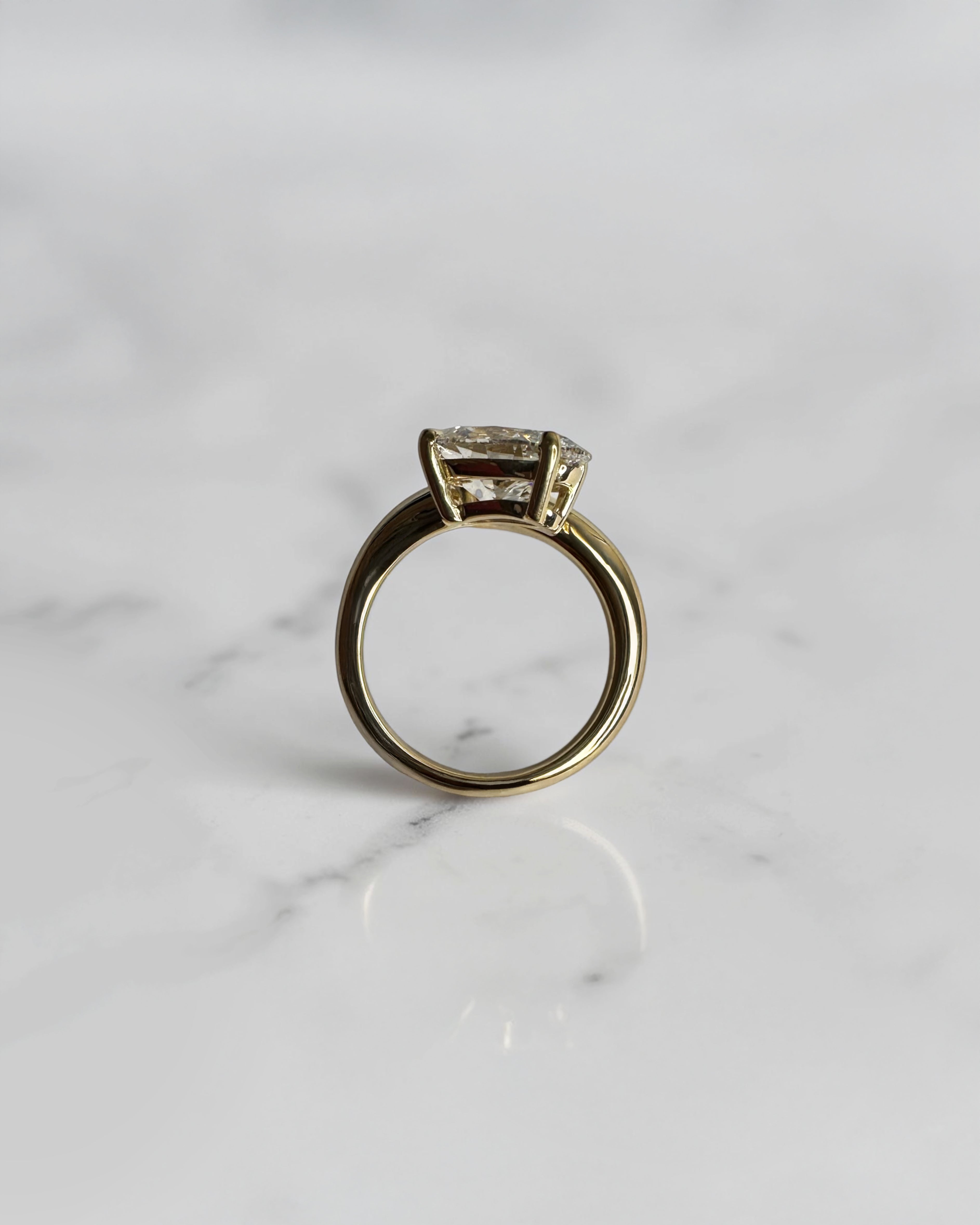 Open band oval diamond engagement ring with smooth curved wrap design in polished yellow gold