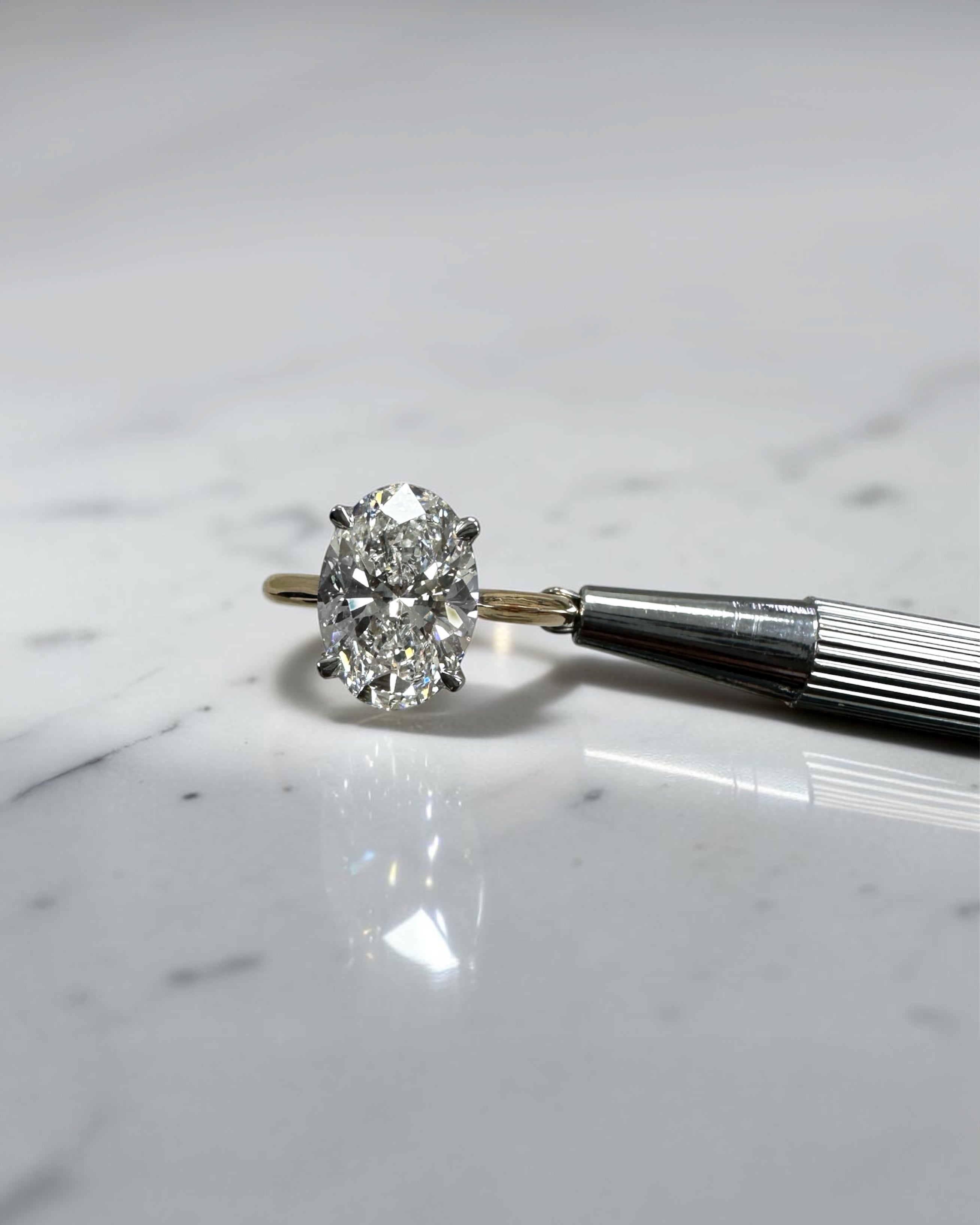 3ct oval cut lab grown diamond engagement ring with hidden halo and cathedral setting in two tone yellow gold plain band with platinum head solitaire, handcrafted in London