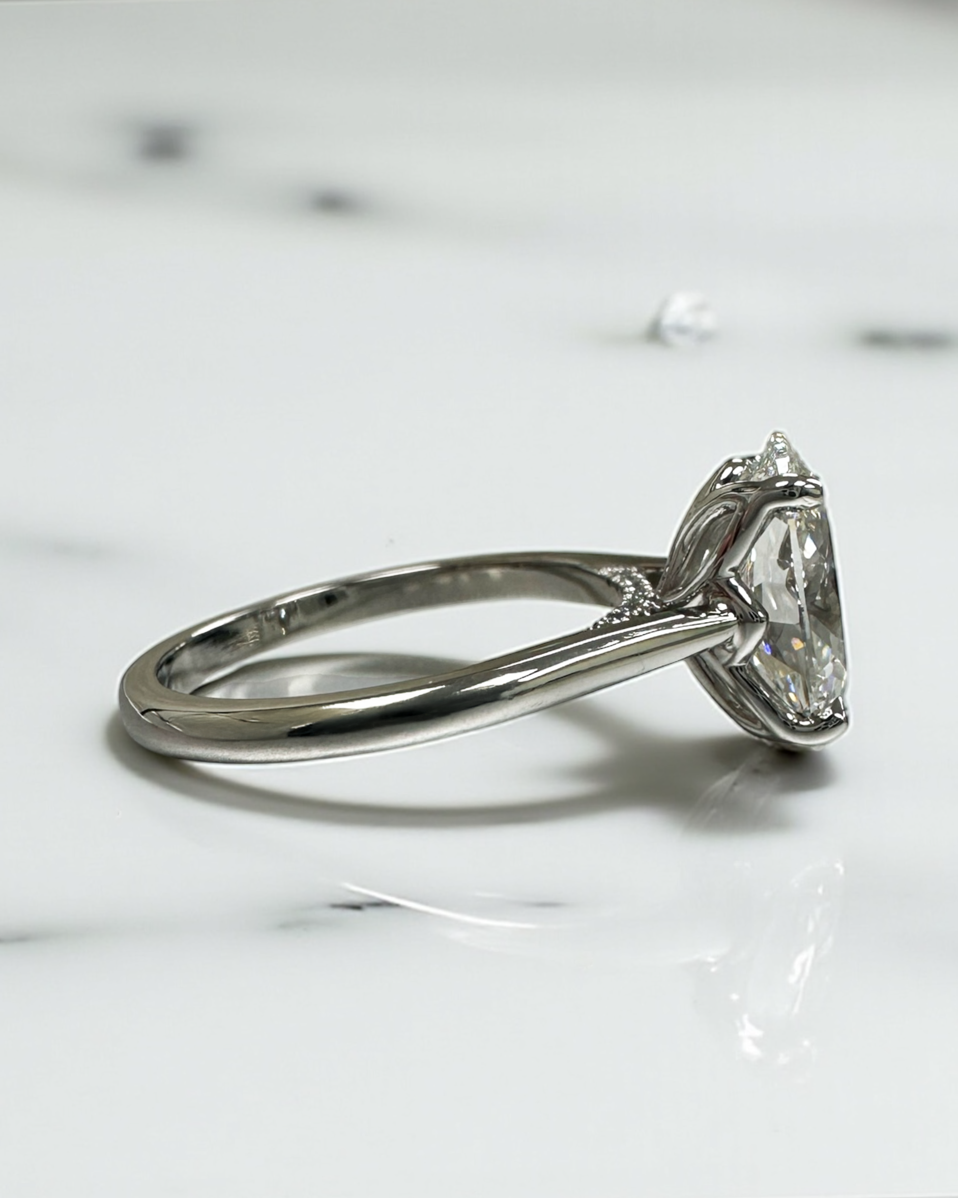 Close up of 3ct oval diamond solitaire ring in platinum cathedral setting with diamond bridge detail — Layla Diamonds London.