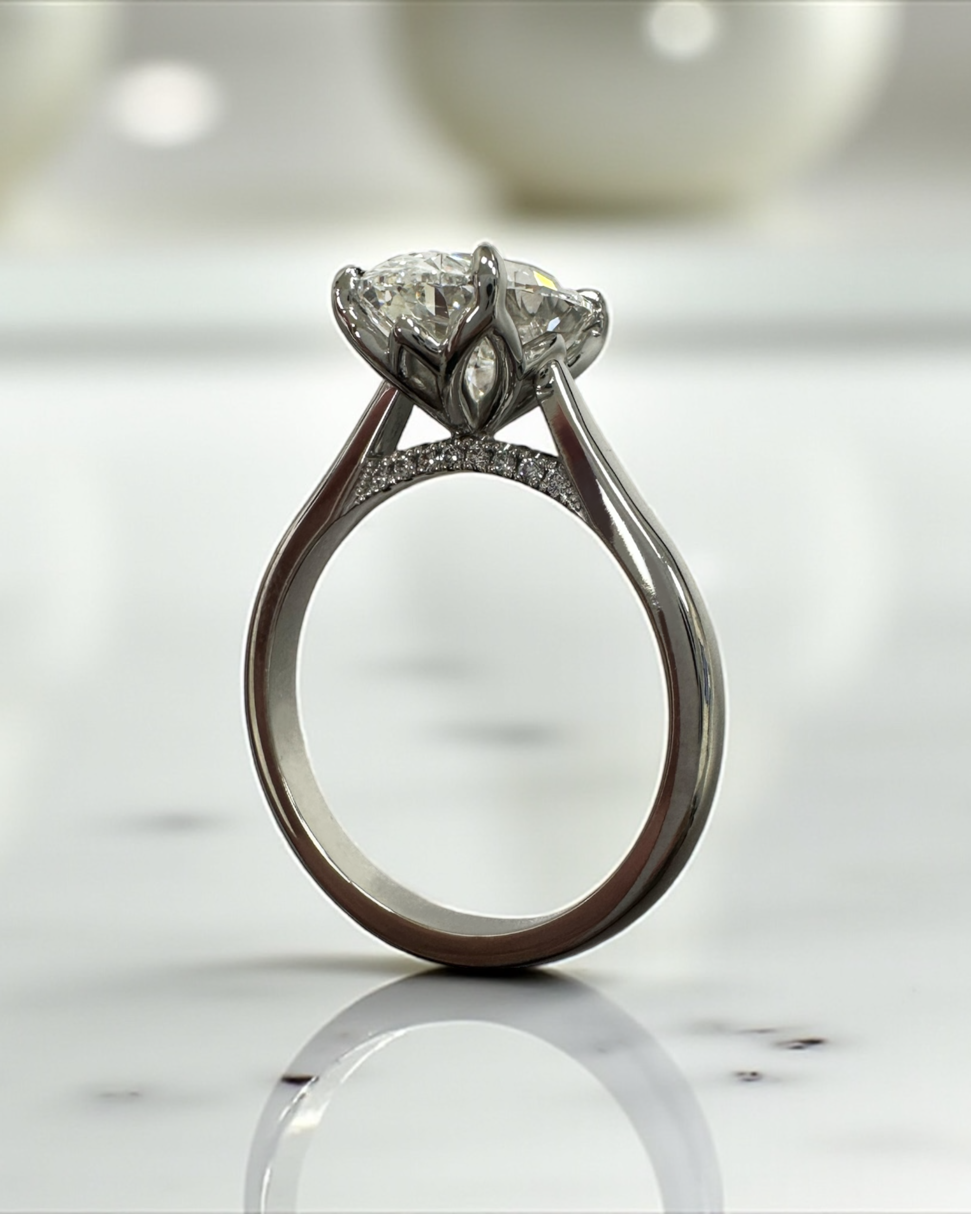 Close up of 3ct oval diamond solitaire ring in platinum cathedral setting with diamond bridge detail lotus head prongs — Layla Diamonds London.