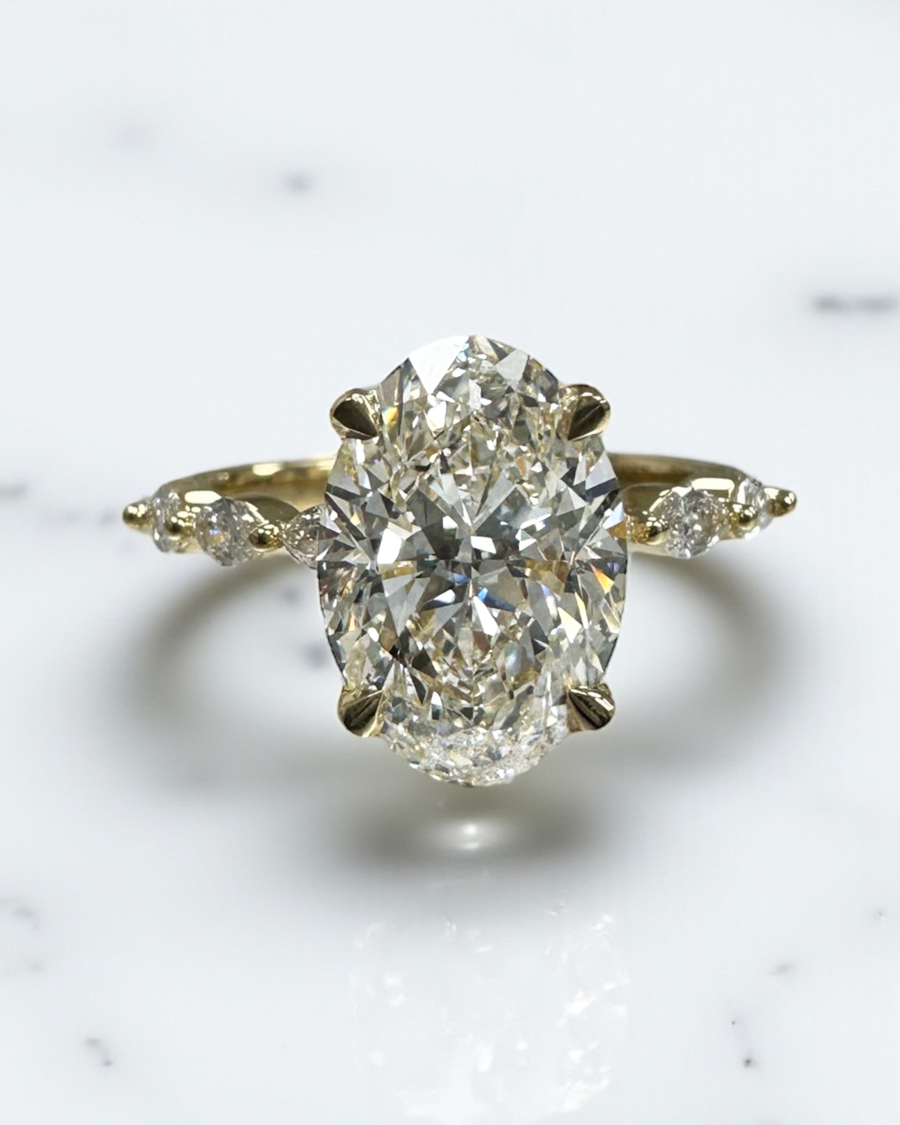 3ct Oval cut lab grown diamond engagement ring with marquise diamond band, crafted in 18kt yellow gold by Layla Diamonds London.