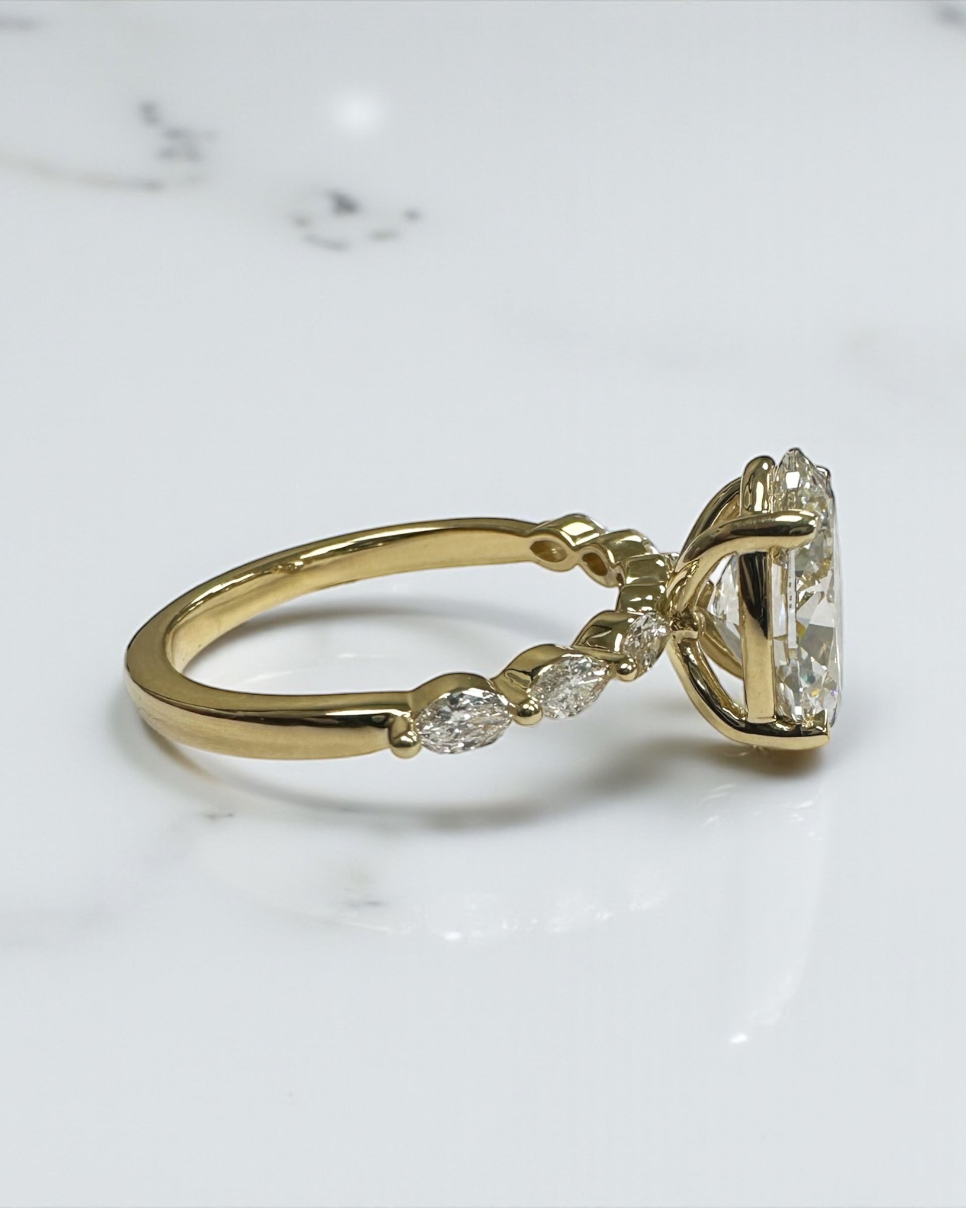 3ct Oval cut lab grown diamond engagement ring with marquise diamond band, crafted in 18kt yellow gold by Layla Diamonds London.