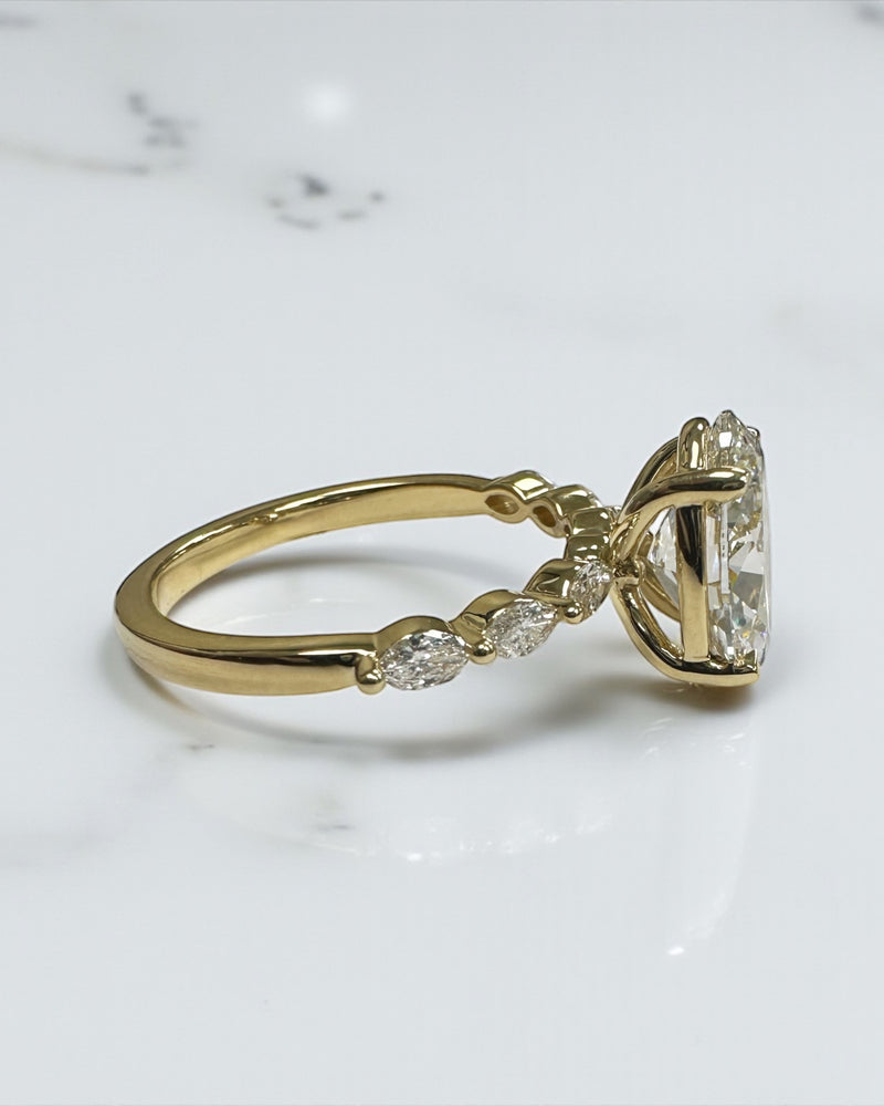 3ct Oval cut lab grown diamond engagement ring with marquise diamond band, crafted in 18kt yellow gold by Layla Diamonds London.