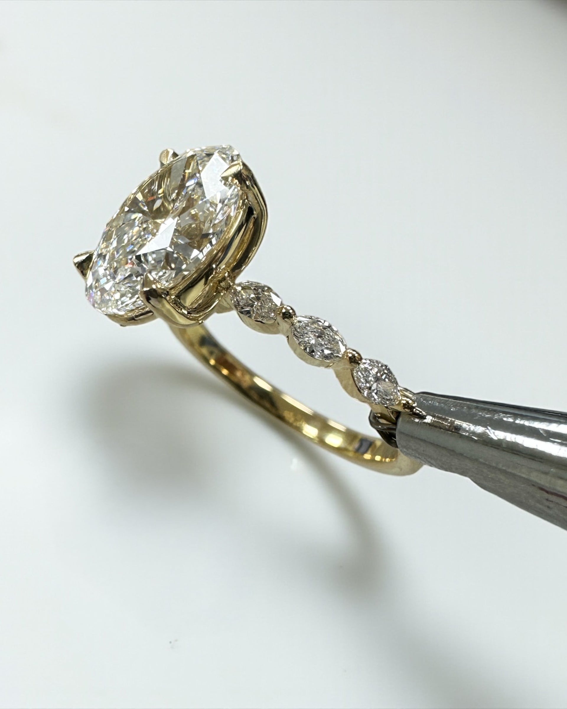 3ct Oval cut lab grown diamond engagement ring with marquise diamond band, crafted in 18kt yellow gold by Layla Diamonds London.