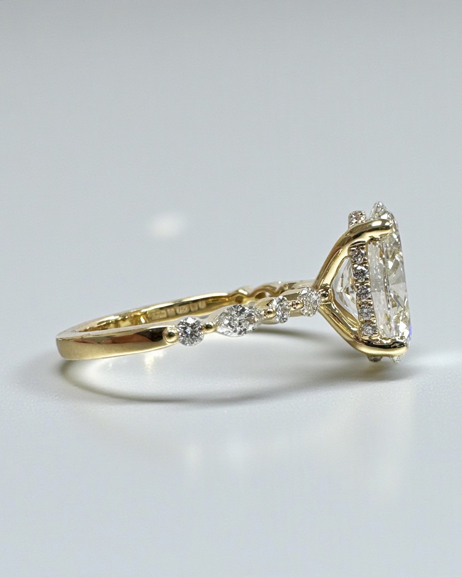 Oval 3ct lab grown diamond ring featuring marquise and round diamond band and delicate hidden halo 18kt yellow gold