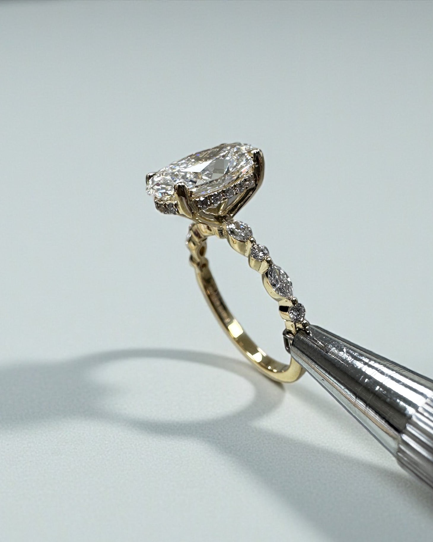 Oval 3ct lab grown diamond ring featuring marquise and round diamond band and delicate hidden halo 18kt yellow gold