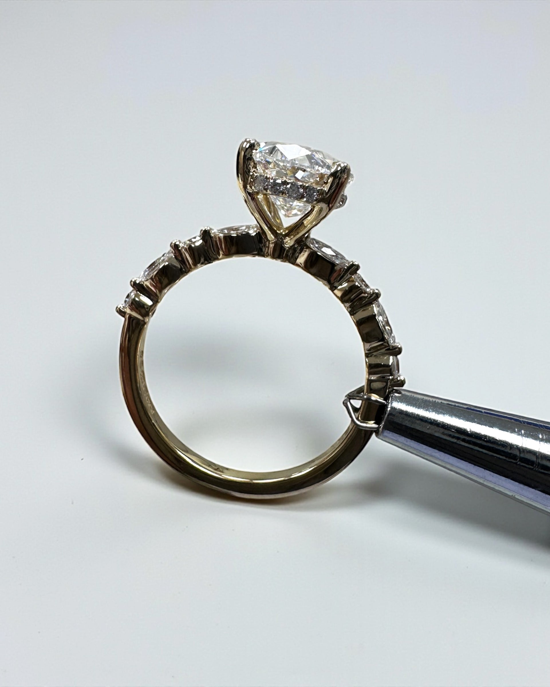 Oval 3ct lab grown diamond ring featuring marquise and round diamond band and delicate hidden halo 18kt yellow gold