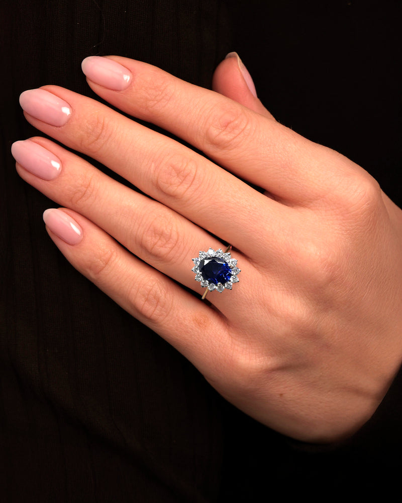 3ct oval cut lab grown blue sapphire halo diamond ring with 0.80ct diamonds. Crafted in 9kt or 18kt gold or platinum. British hallmarked.
