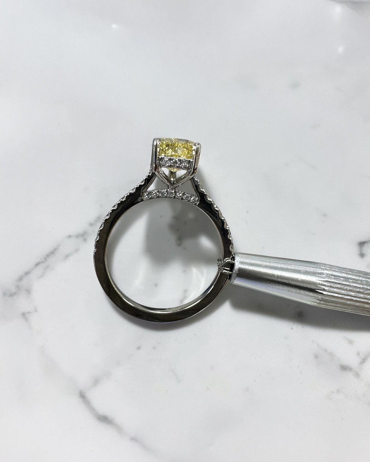 Yellow pear cut diamond engagement ring featuring a diamond hidden halo and bridge