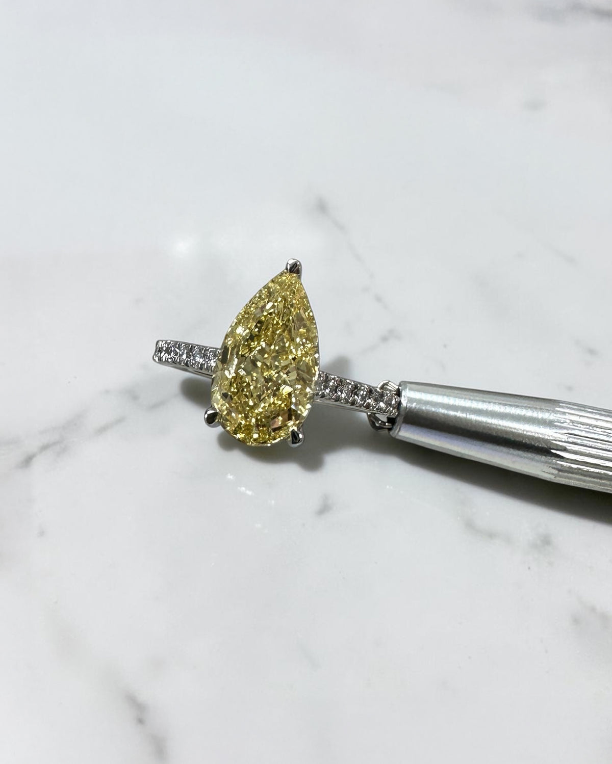 3ct yellow pear diamond engagement ring with elevated cathedral setting and diamond band
