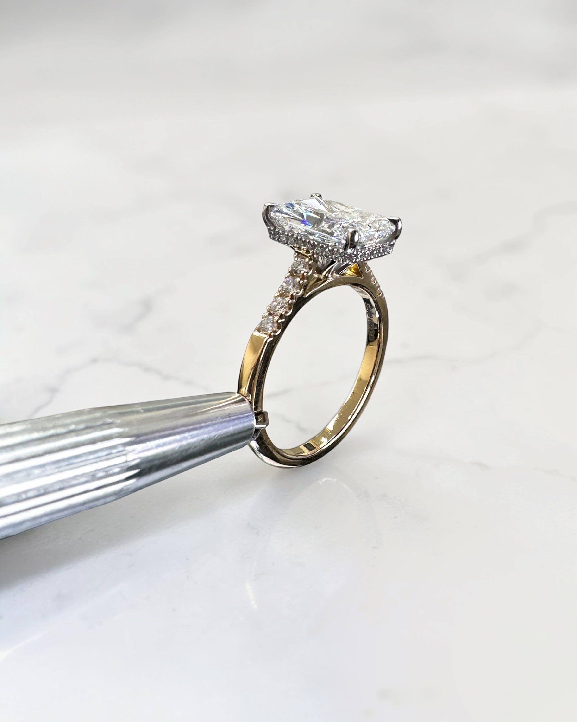 3ct radiant cut lab grown diamond engagement ring with partial pavé band, cathedral setting, hidden halo and two tone yellow gold band