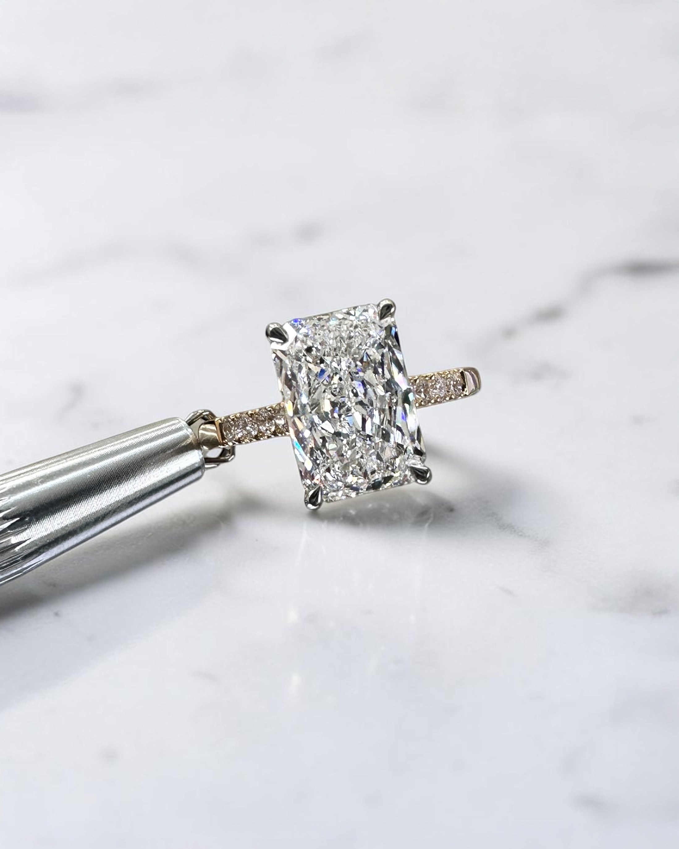 3ct radiant cut lab grown diamond engagement ring with partial pavé band, cathedral setting, hidden halo and two tone yellow gold band
