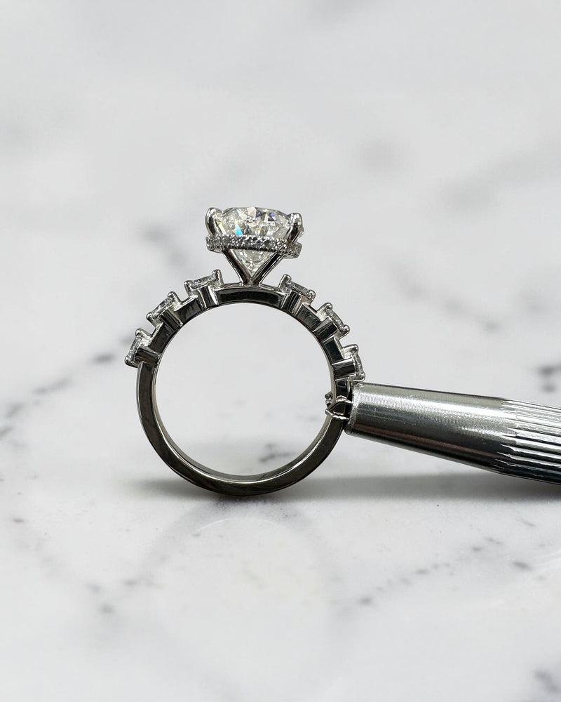 4ct oval lab grown diamond hidden halo engagement ring with floating cathedral setting and spaced diamond band in platinum.