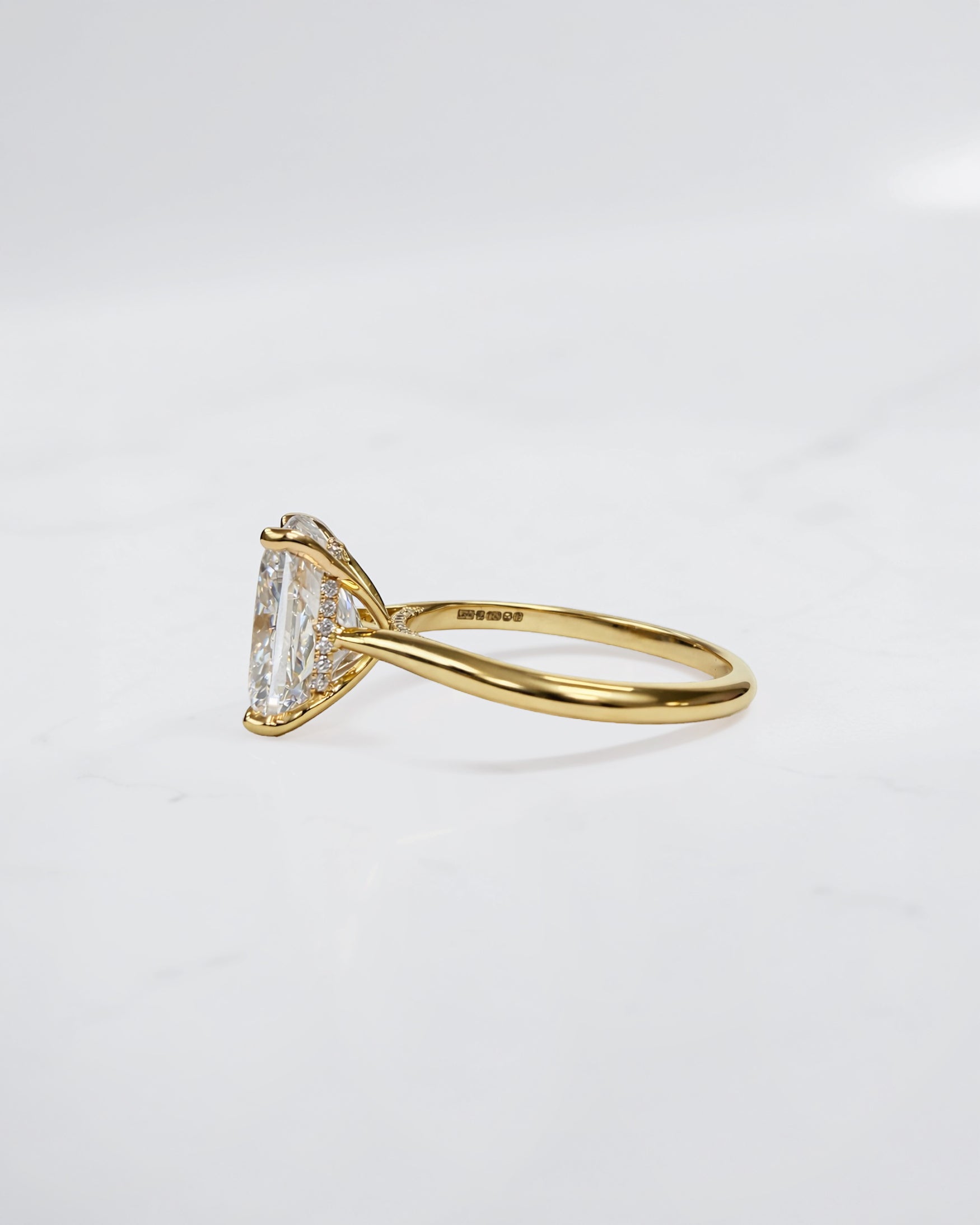 4ct elongated cushion cut lab grown diamond engagement ring in 18kt yellow gold with cathedral setting and hidden halo.