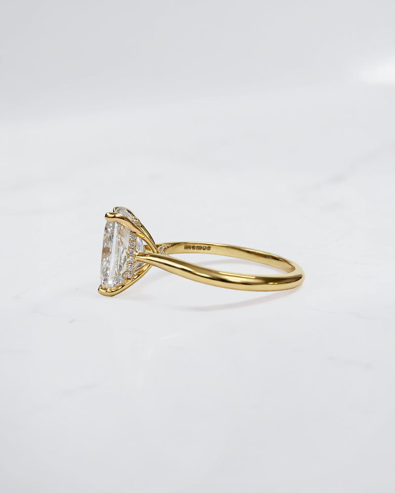 4ct elongated cushion cut lab grown diamond engagement ring in 18kt yellow gold with cathedral setting and hidden halo.