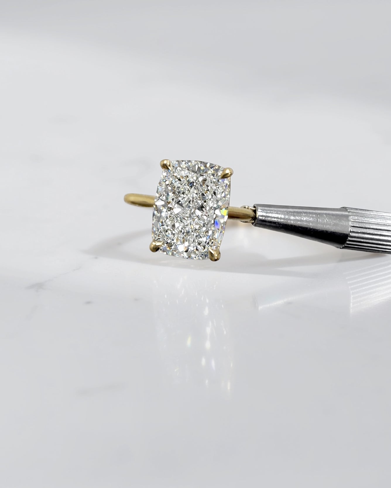 4ct elongated cushion cut lab grown diamond engagement ring in 18kt yellow gold with cathedral setting and hidden halo.