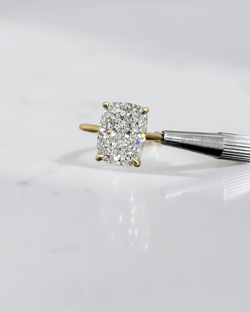 4ct elongated cushion cut lab grown diamond engagement ring in 18kt yellow gold with cathedral setting and hidden halo.