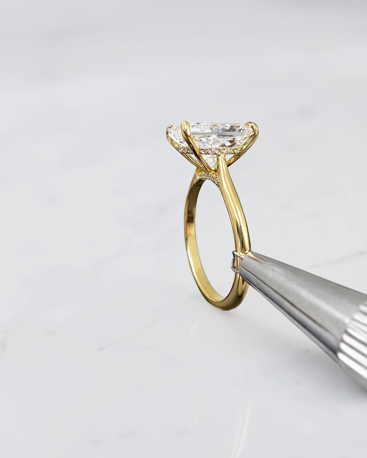 4ct elongated cushion cut lab grown diamond engagement ring in 18kt yellow gold with cathedral setting and hidden halo.