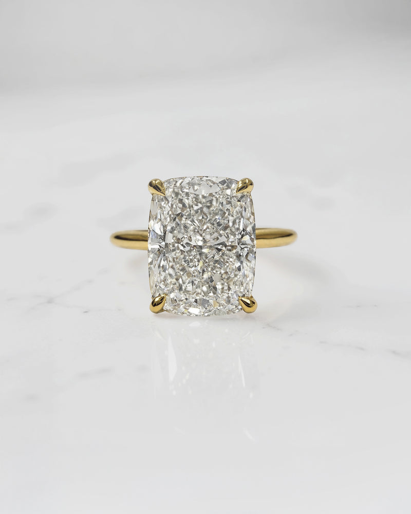 4ct elongated cushion cut lab grown diamond engagement ring in 18kt yellow gold with cathedral setting and hidden halo.