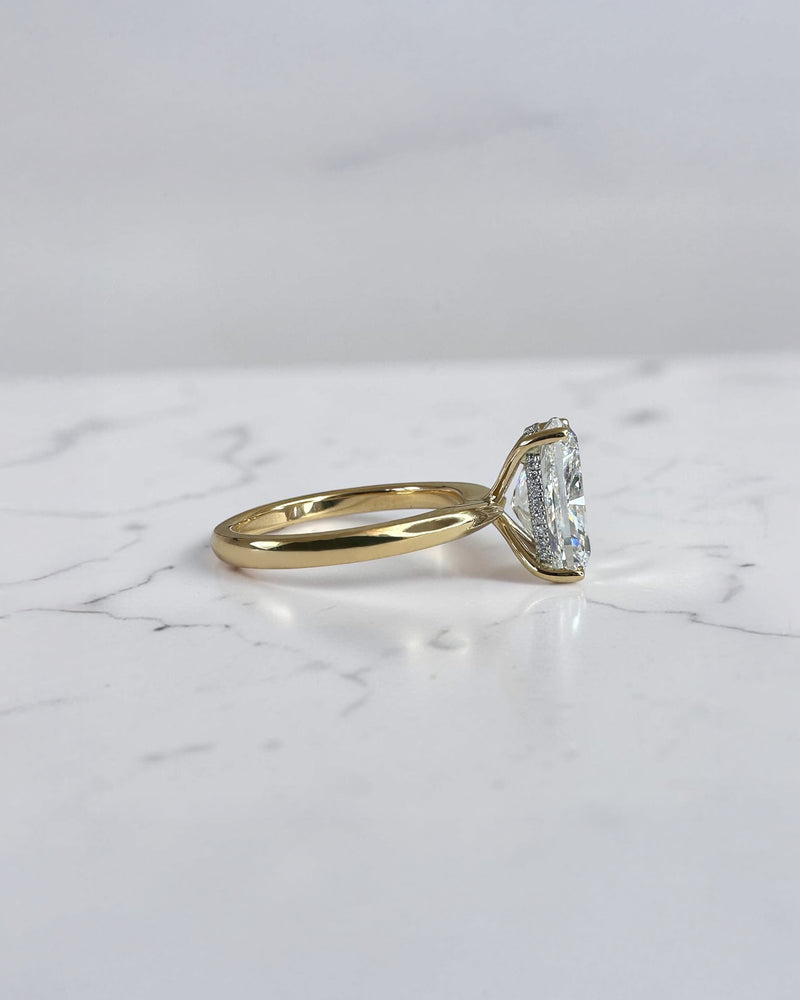 4ct elongated cushion cut lab grown diamond hidden halo solitaire engagement ring in yellow gold with floating cathedral style setting, handmade in London.