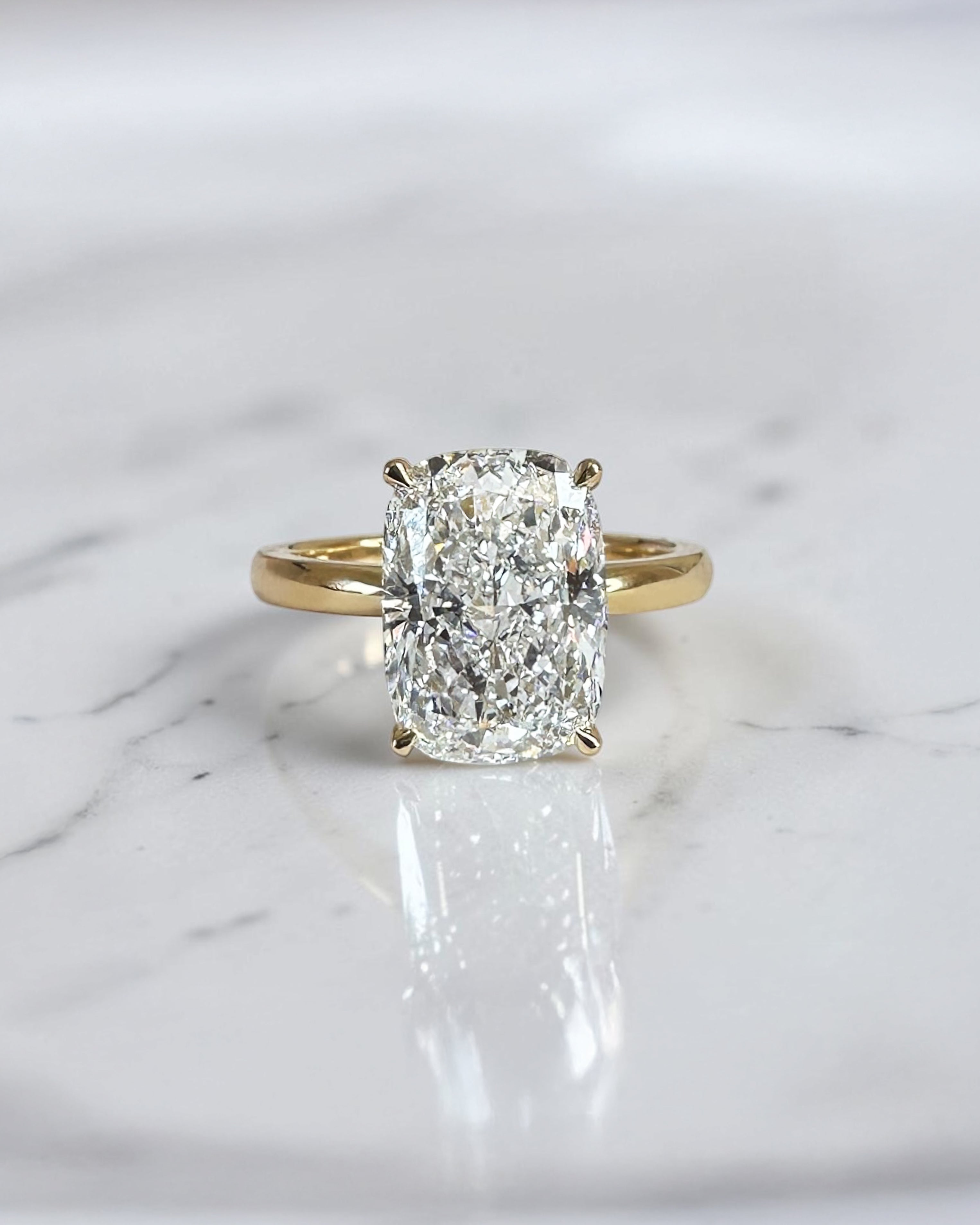 4ct elongated cushion cut lab grown diamond hidden halo solitaire engagement ring in yellow gold with floating cathedral style setting, handmade in London.