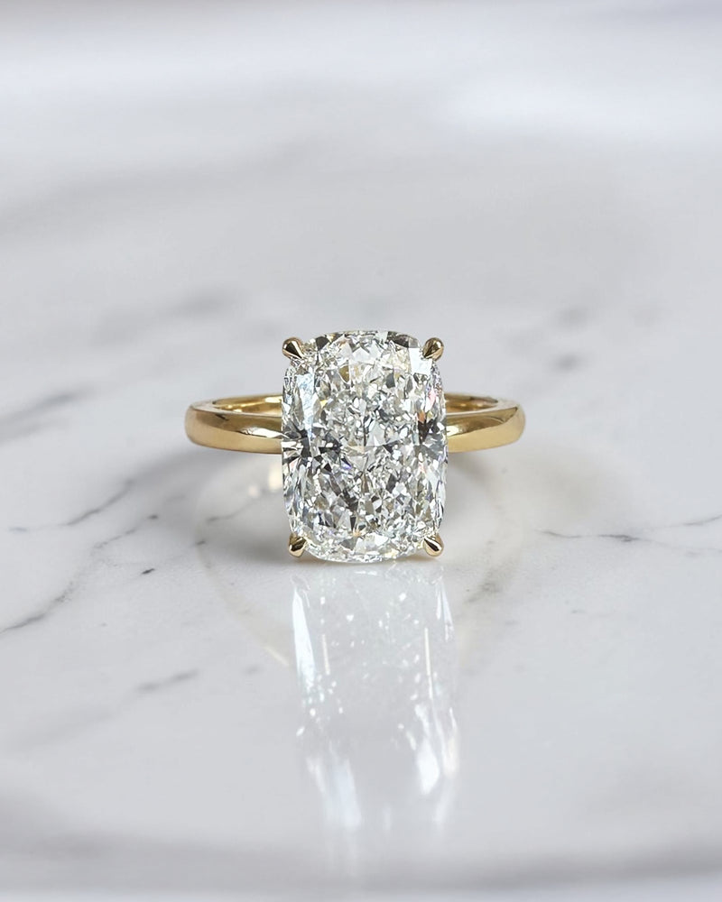 4ct elongated cushion cut lab grown diamond hidden halo solitaire engagement ring in yellow gold with floating cathedral style setting, handmade in London.