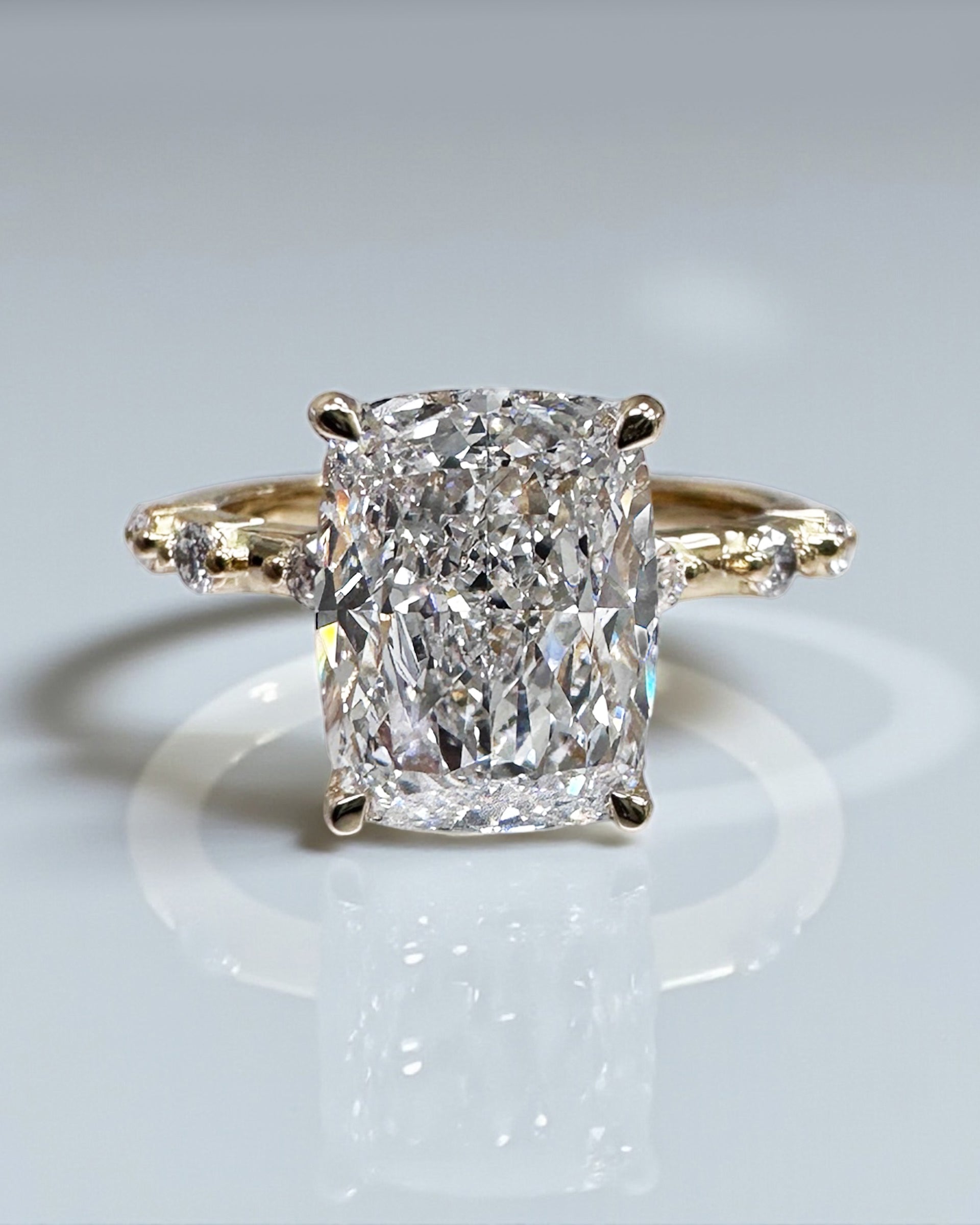 4ct elongated cushion cut lab grown diamond engagement ring with spaced diamond band and hidden halo in 18kt gold on hand