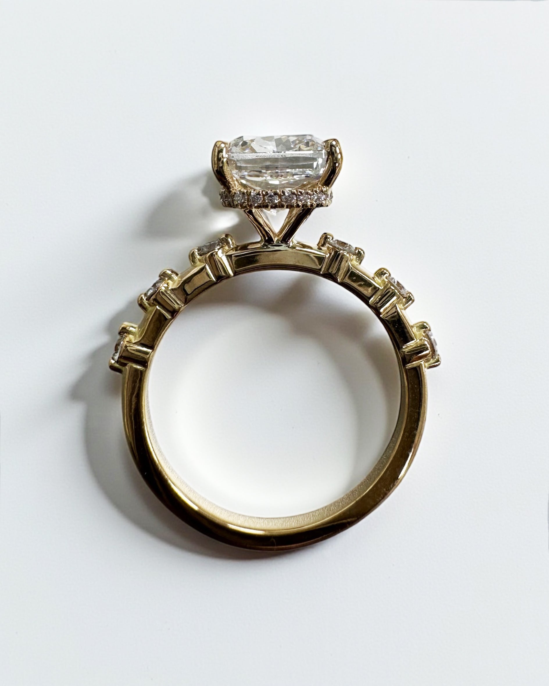 4ct elongated cushion cut lab grown diamond engagement ring with spaced diamond band and hidden halo in 18kt gold 