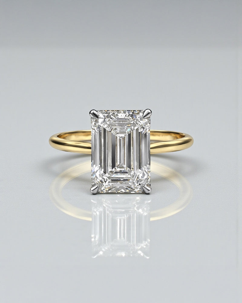 4ct emerald cut lab grown diamond engagement ring with hidden halo and diamond bridge in a cathedral setting 18kt yellow gold 