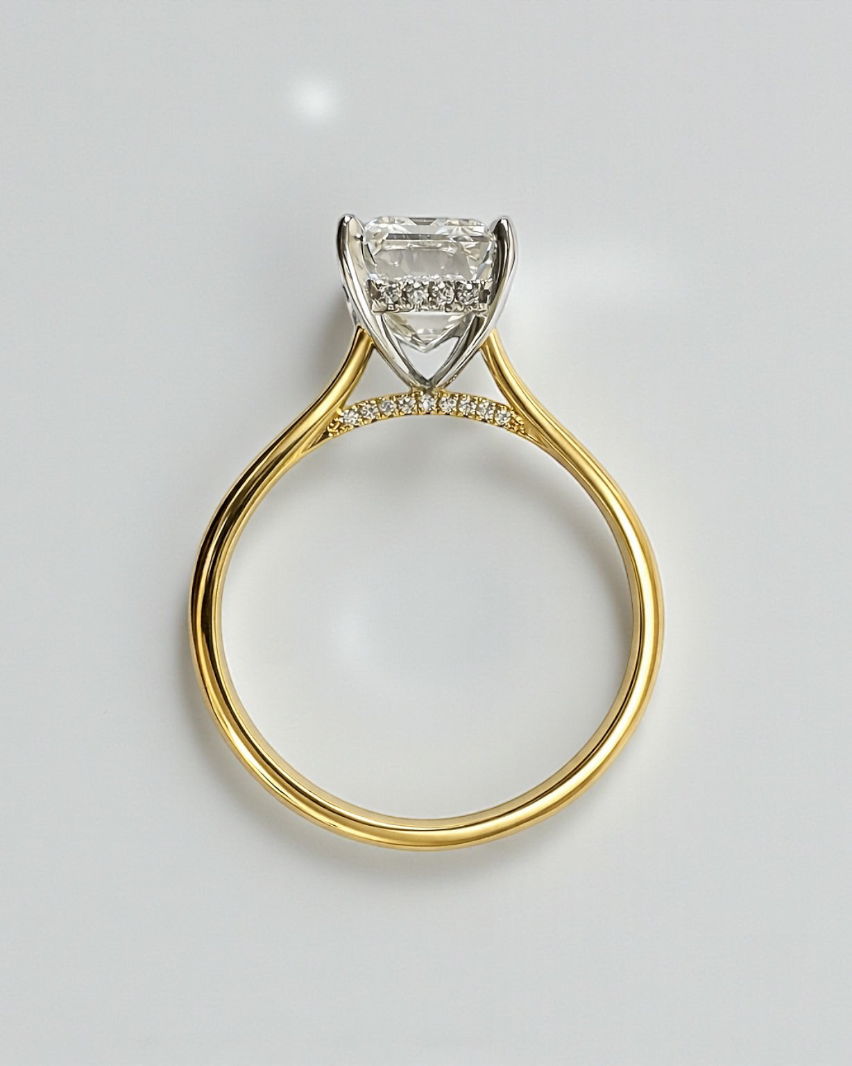 4ct emerald cut lab grown diamond engagement ring with hidden halo and diamond bridge in a cathedral setting 18kt yellow gold 