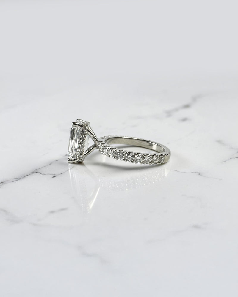 4ct emerald cut lab grown diamond engagement ring with floating diamond shoulder band and diamond wrap around hidden halo in platinum.
