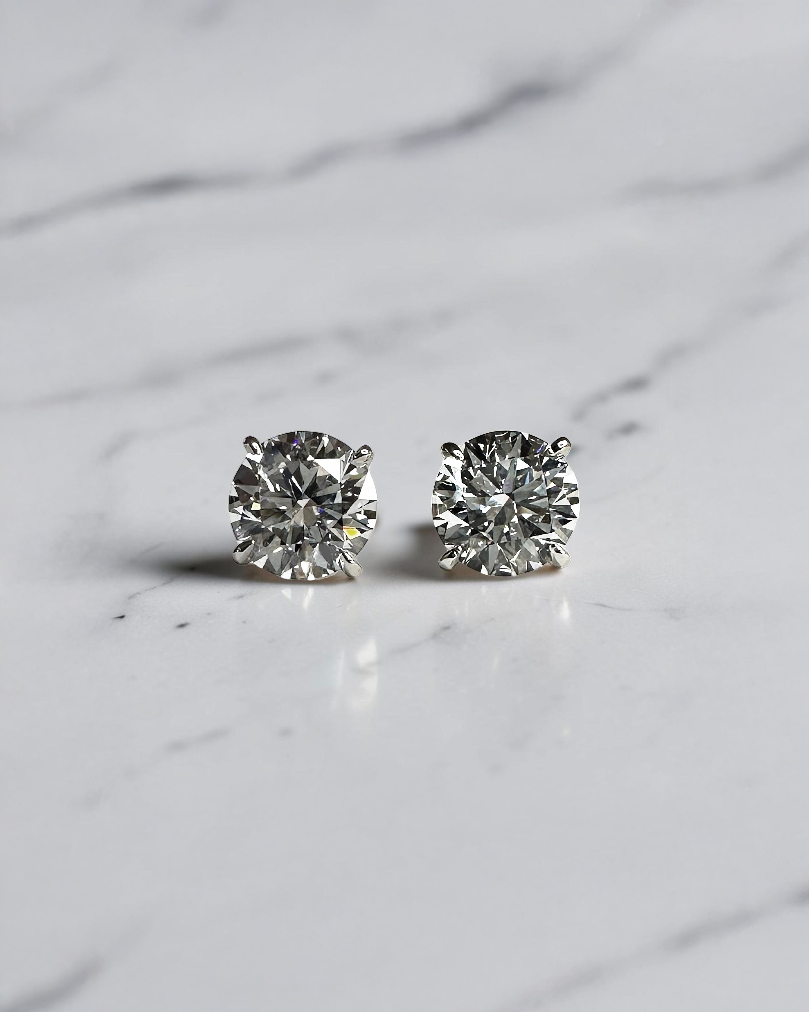 4ct round brilliant lab grown diamond martini stud earrings featuring 2ct E VVS2+ diamonds in a classic four prong martini setting with secure butterfly backs.