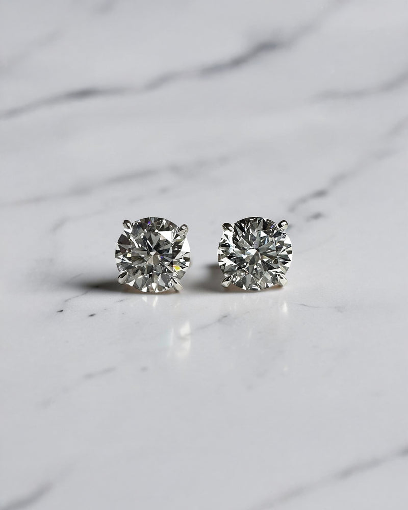 4ct round brilliant lab grown diamond martini stud earrings featuring 2ct E VVS2+ diamonds in a classic four prong martini setting with secure butterfly backs.