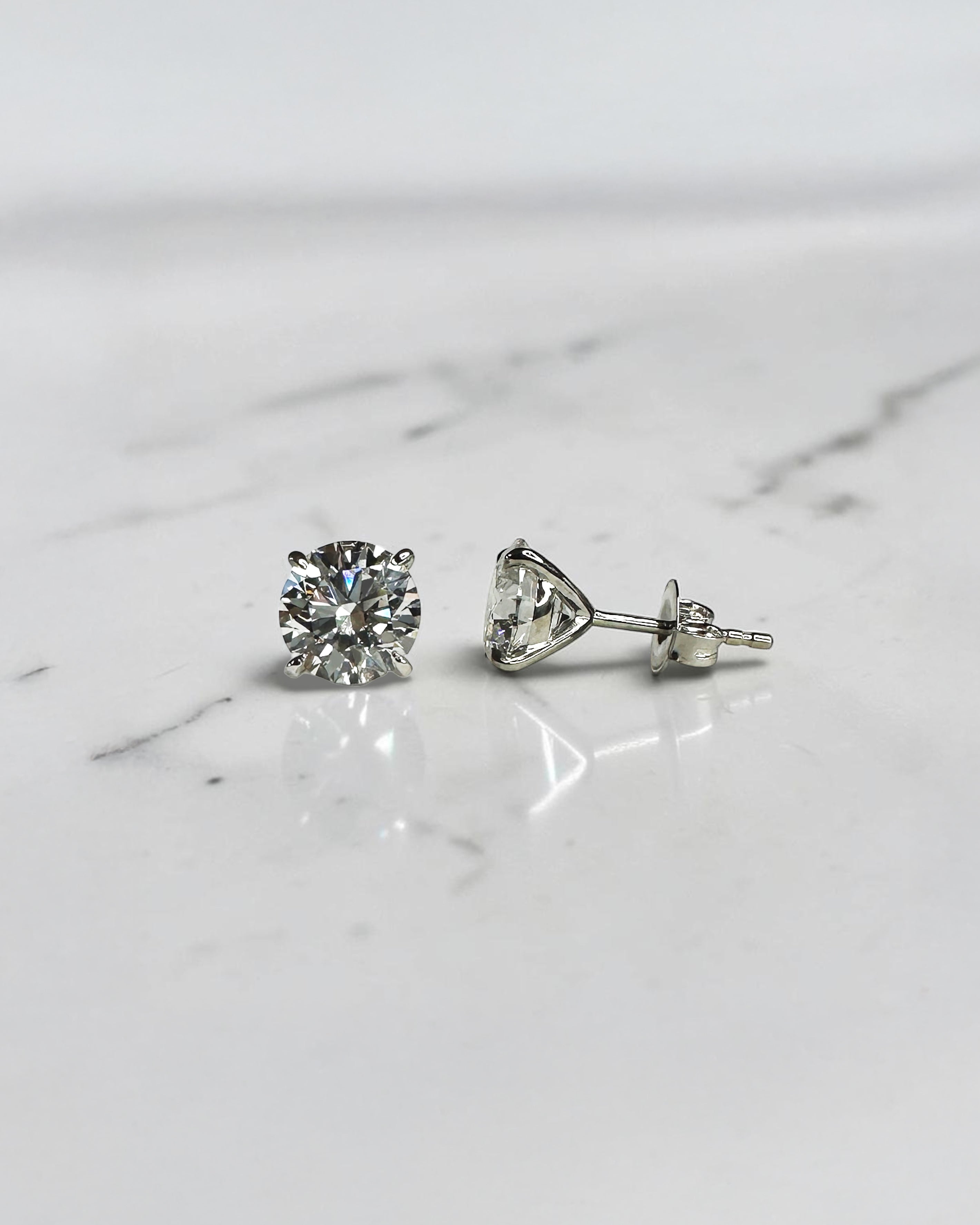 4ct round brilliant lab grown diamond martini stud earrings featuring 2ct E VVS2+ diamonds in a classic four prong martini setting with secure butterfly backs.