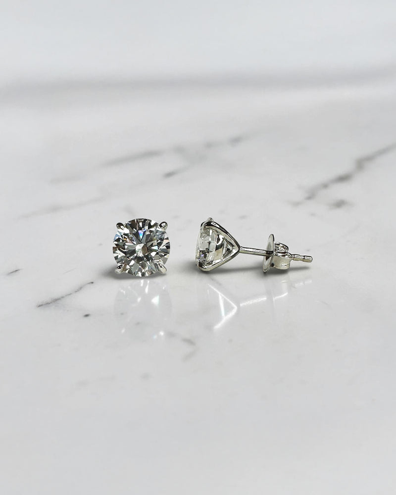 4ct round brilliant lab grown diamond martini stud earrings featuring 2ct E VVS2+ diamonds in a classic four prong martini setting with secure butterfly backs.