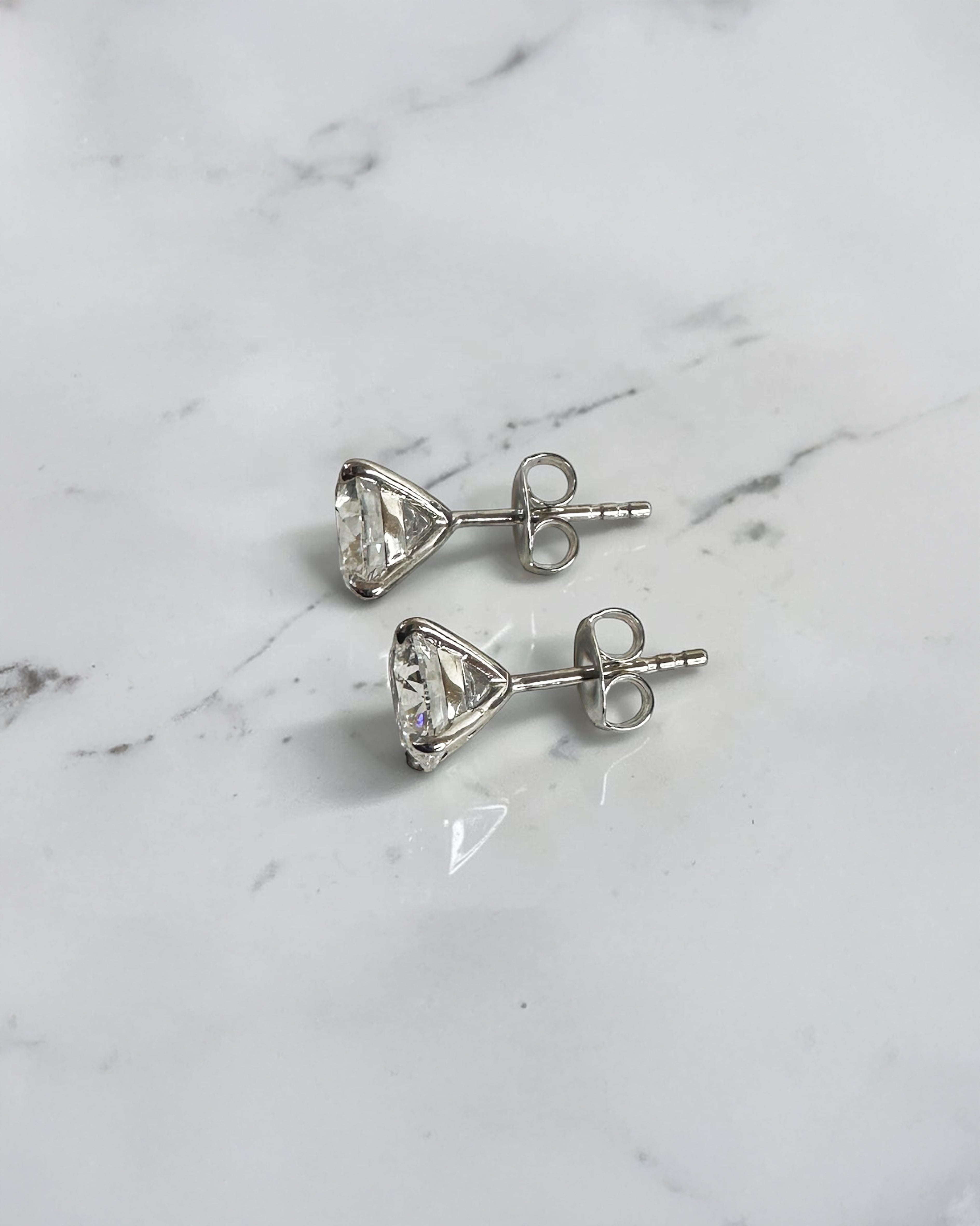 4ct round brilliant lab grown diamond martini stud earrings featuring 2ct E VVS2+ diamonds in a classic four prong martini setting with secure butterfly backs.