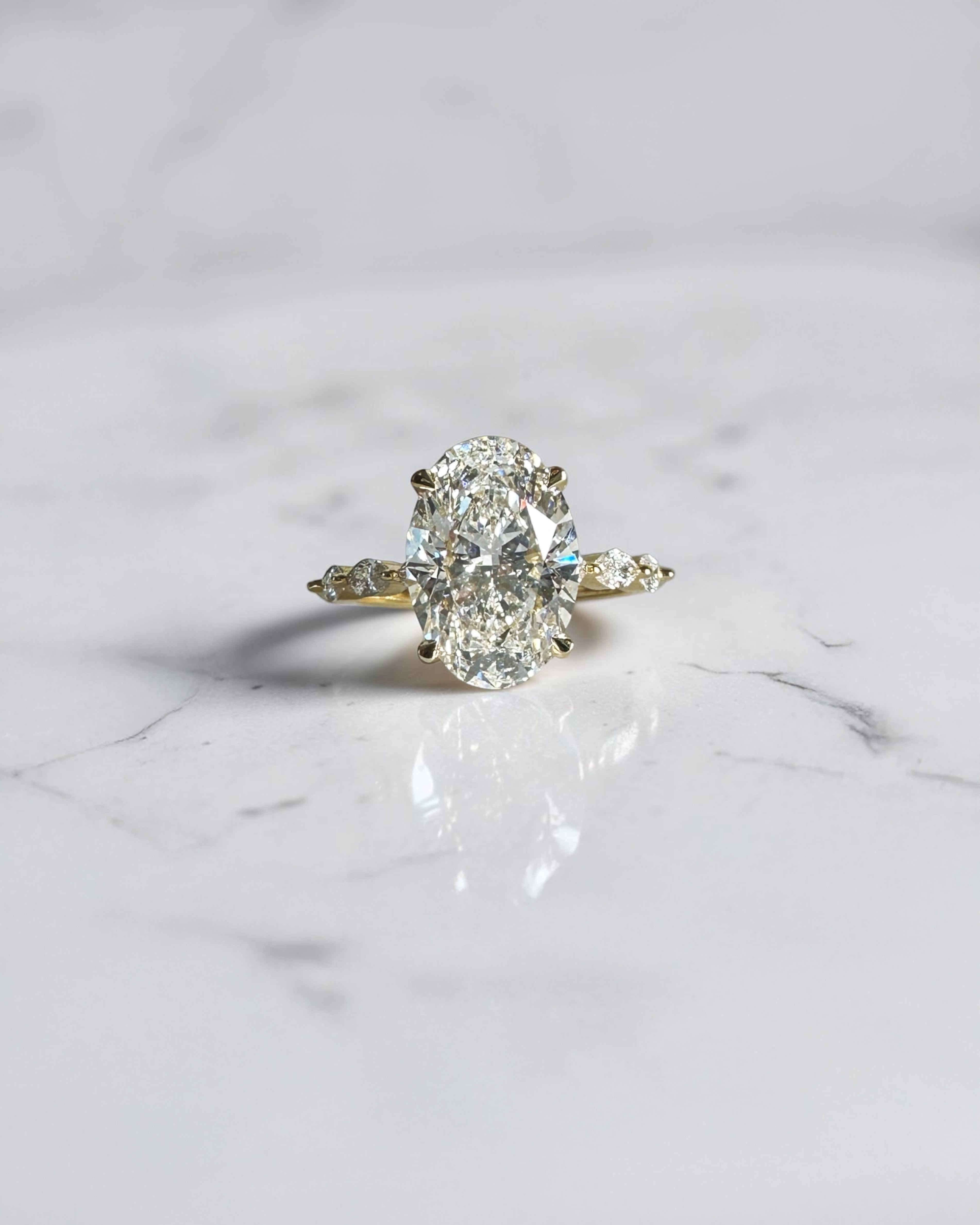 4ct oval cut lab grown diamond engagement ring with marquise cut diamond band in yellow gold, four claw setting, 4.40ct total diamond weight, handcrafted in London