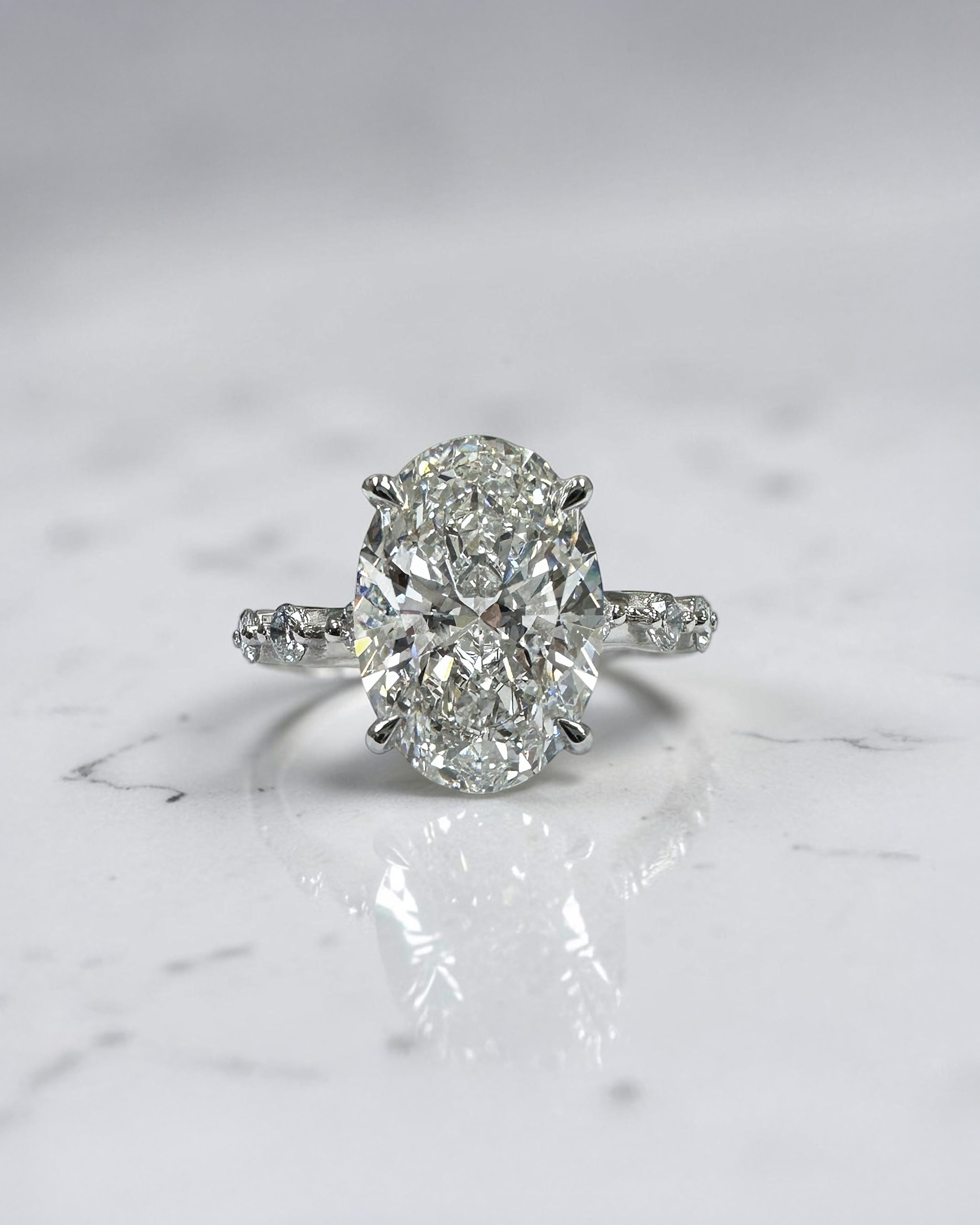 4ct oval lab grown diamond hidden halo engagement ring with floating cathedral setting and spaced diamond band in platinum.