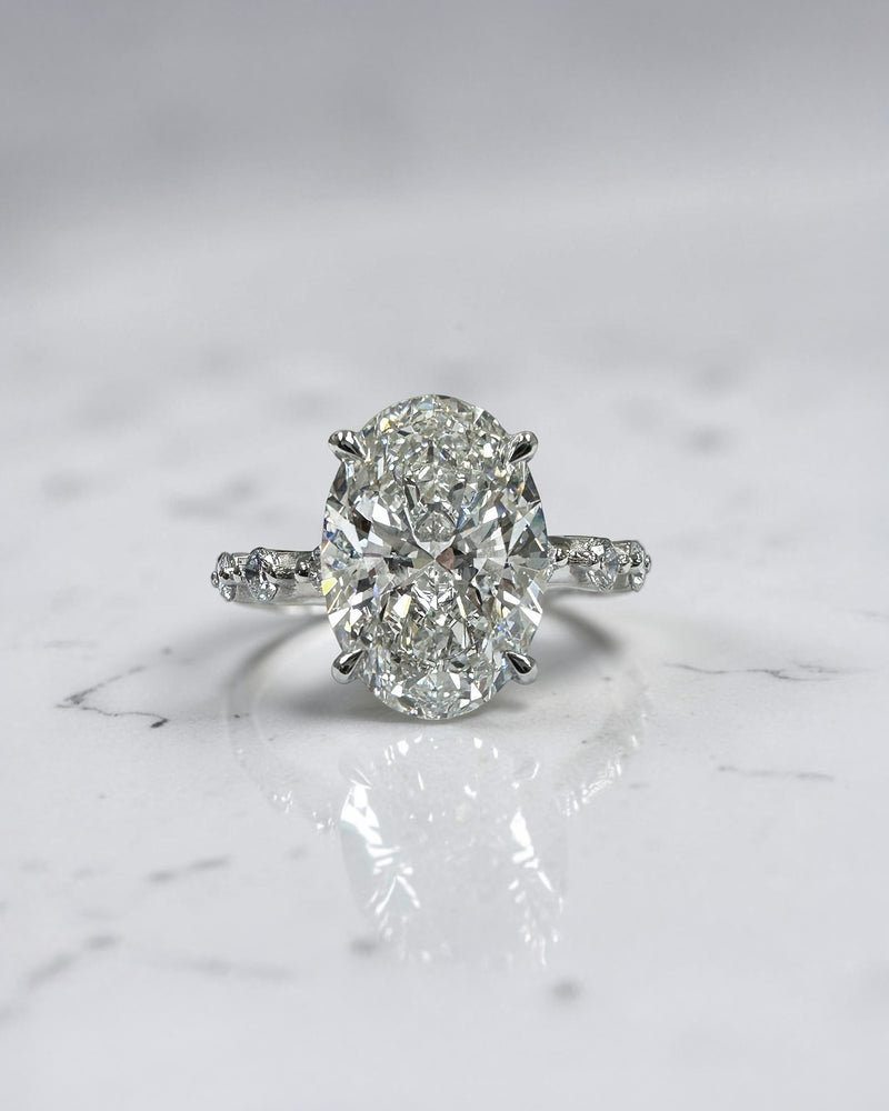 4ct oval lab grown diamond hidden halo engagement ring with floating cathedral setting and spaced diamond band in platinum.
