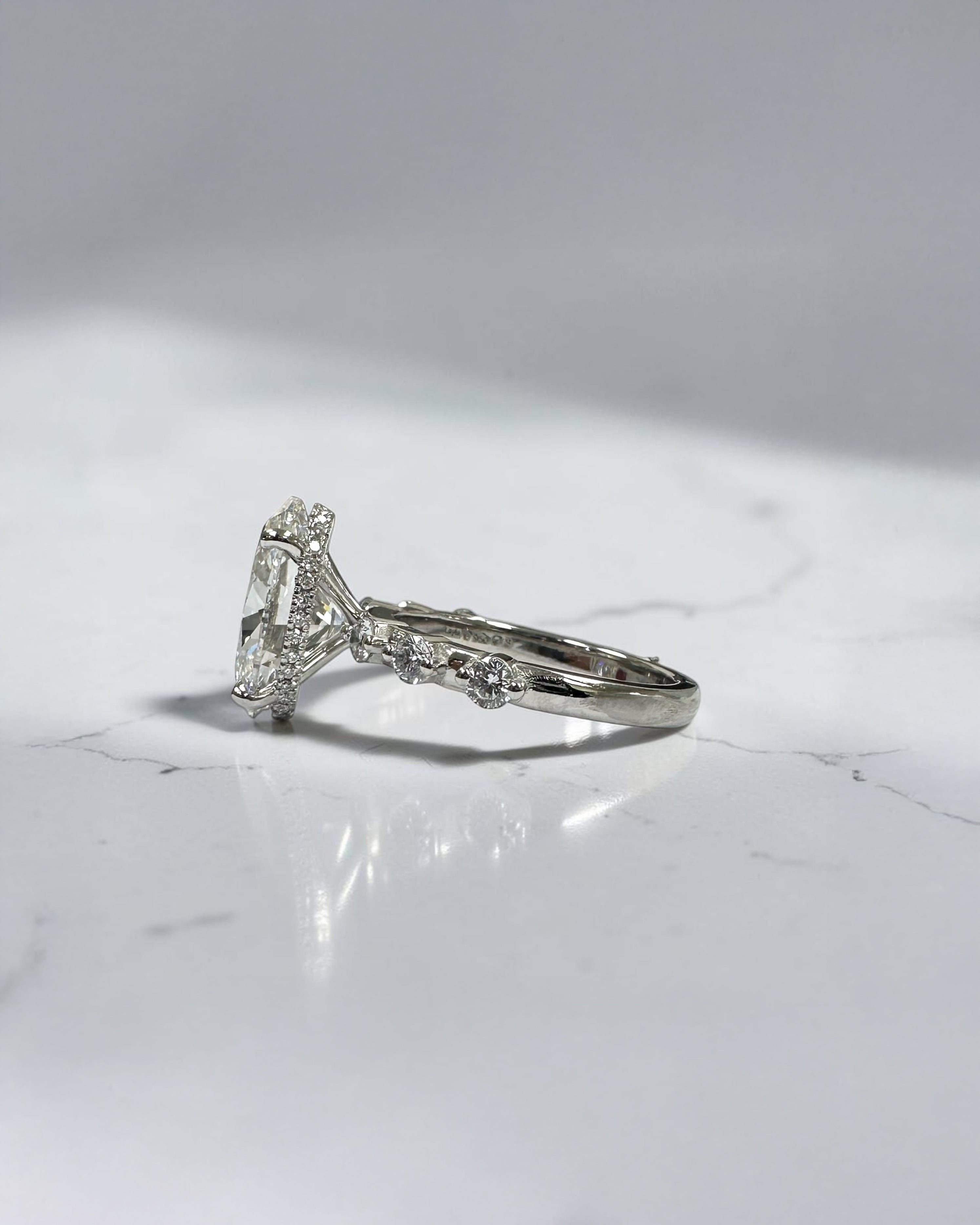 4ct oval lab grown diamond hidden halo engagement ring with floating cathedral setting and spaced diamond band in platinum.