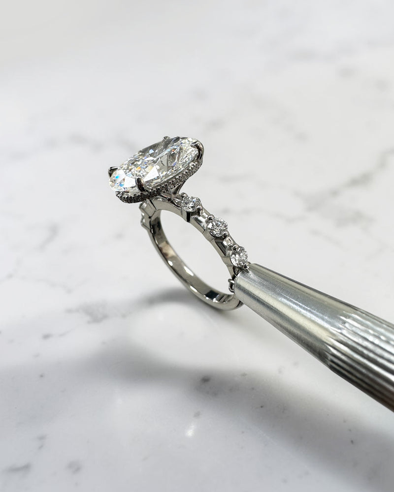 4ct oval lab grown diamond hidden halo engagement ring with floating cathedral setting and spaced diamond band in platinum.