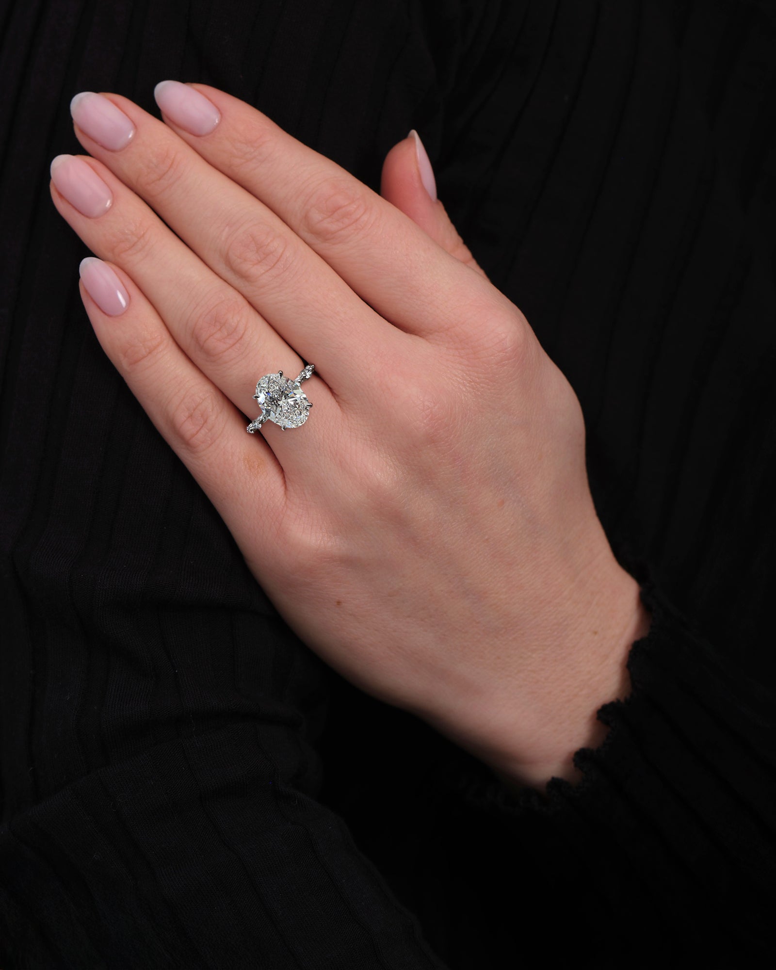 4ct oval lab grown diamond hidden halo engagement ring with floating cathedral setting and spaced diamond band in platinum on hand