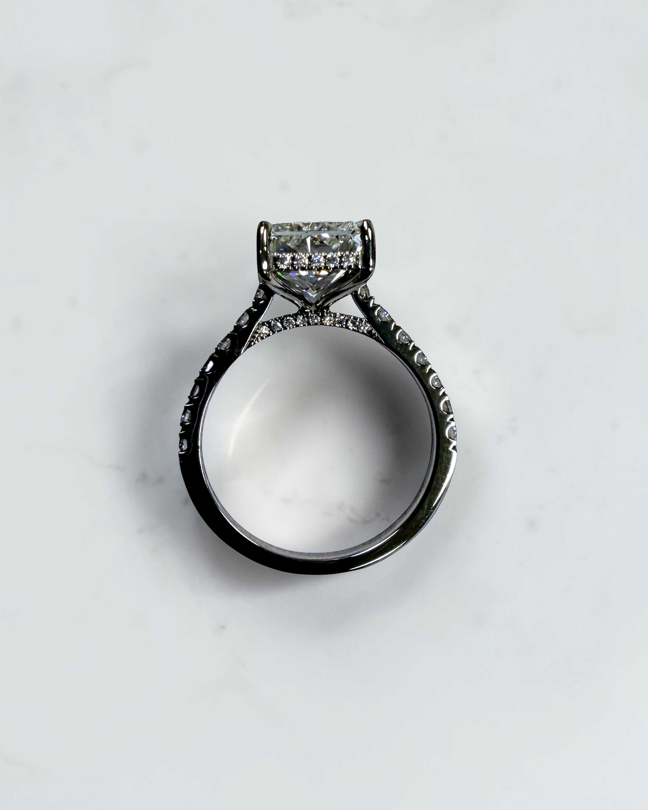 4ct radiant cut lab grown diamond engagement ring with cathedral setting, hidden halo and diamond band. Available in platinum or 18kt yellow or white gold