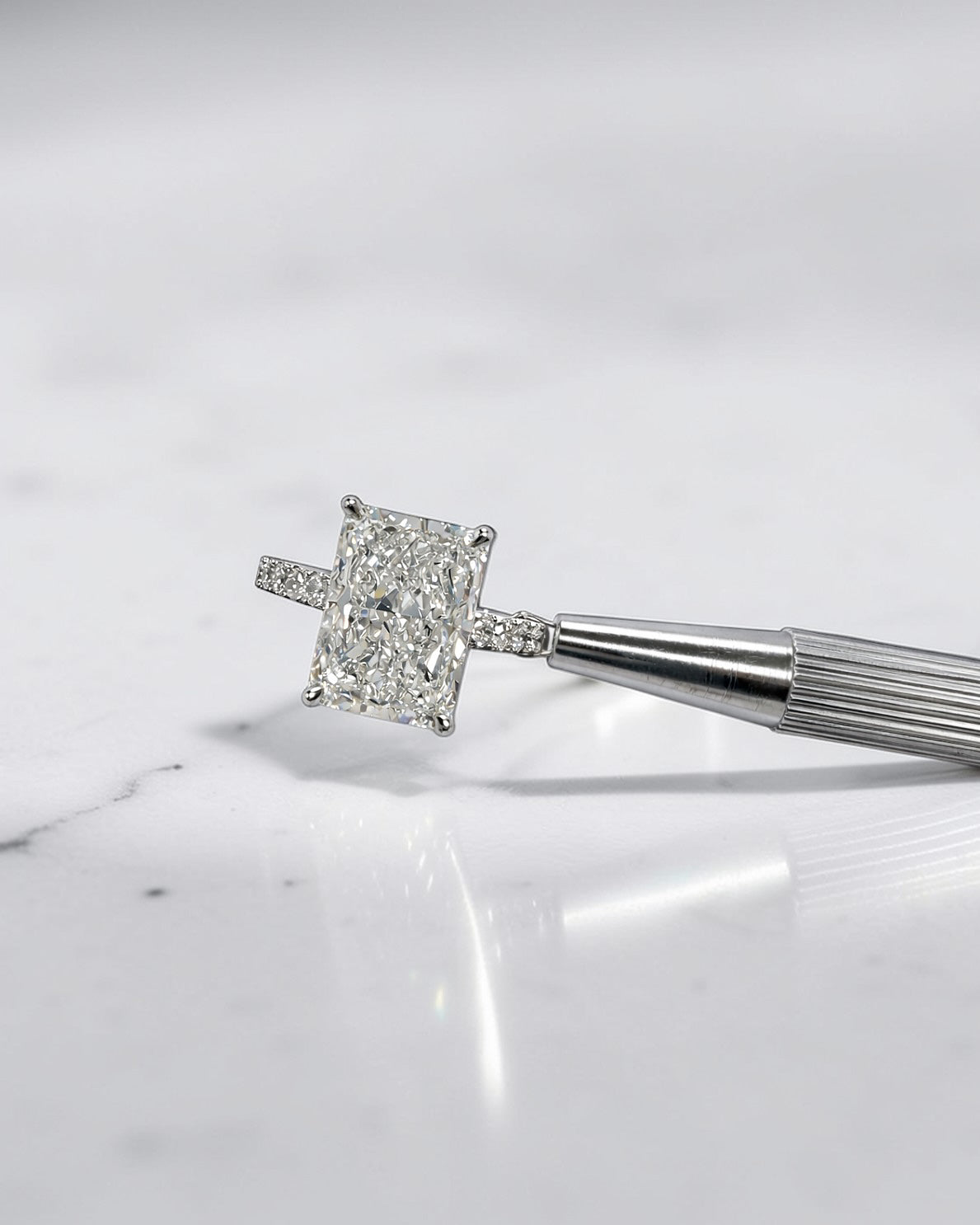 4ct radiant cut lab grown diamond engagement ring with cathedral setting, hidden halo and diamond band. Available in platinum or 18kt yellow or white gold