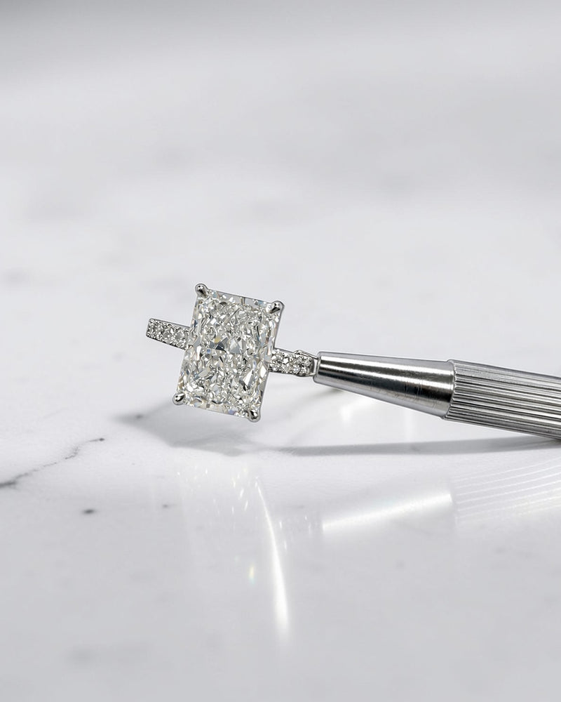4ct radiant cut lab grown diamond engagement ring with cathedral setting, hidden halo and diamond band. Available in platinum or 18kt yellow or white gold