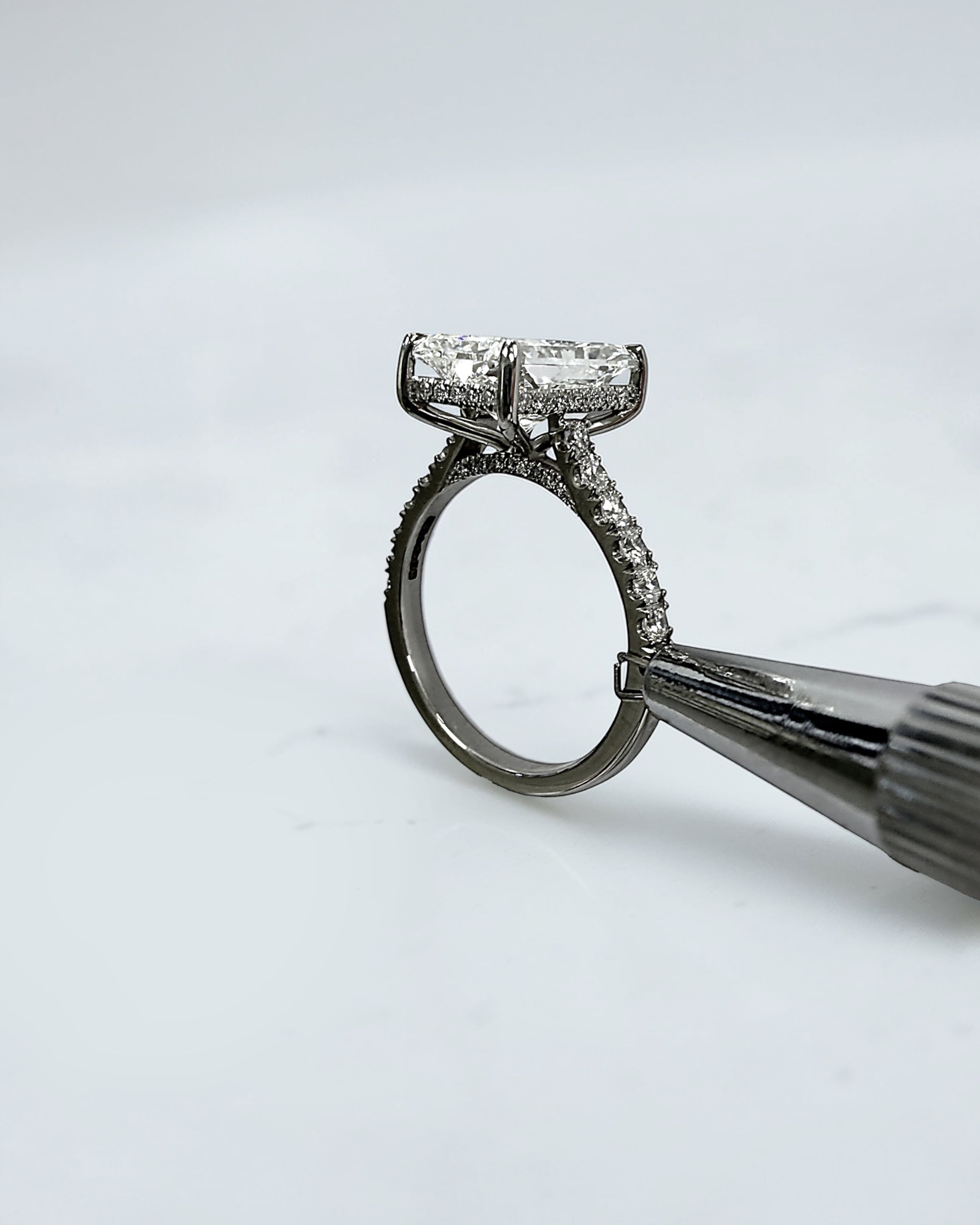 4ct radiant cut lab grown diamond engagement ring with cathedral setting, hidden halo and diamond band. Available in platinum or 18kt yellow or white gold