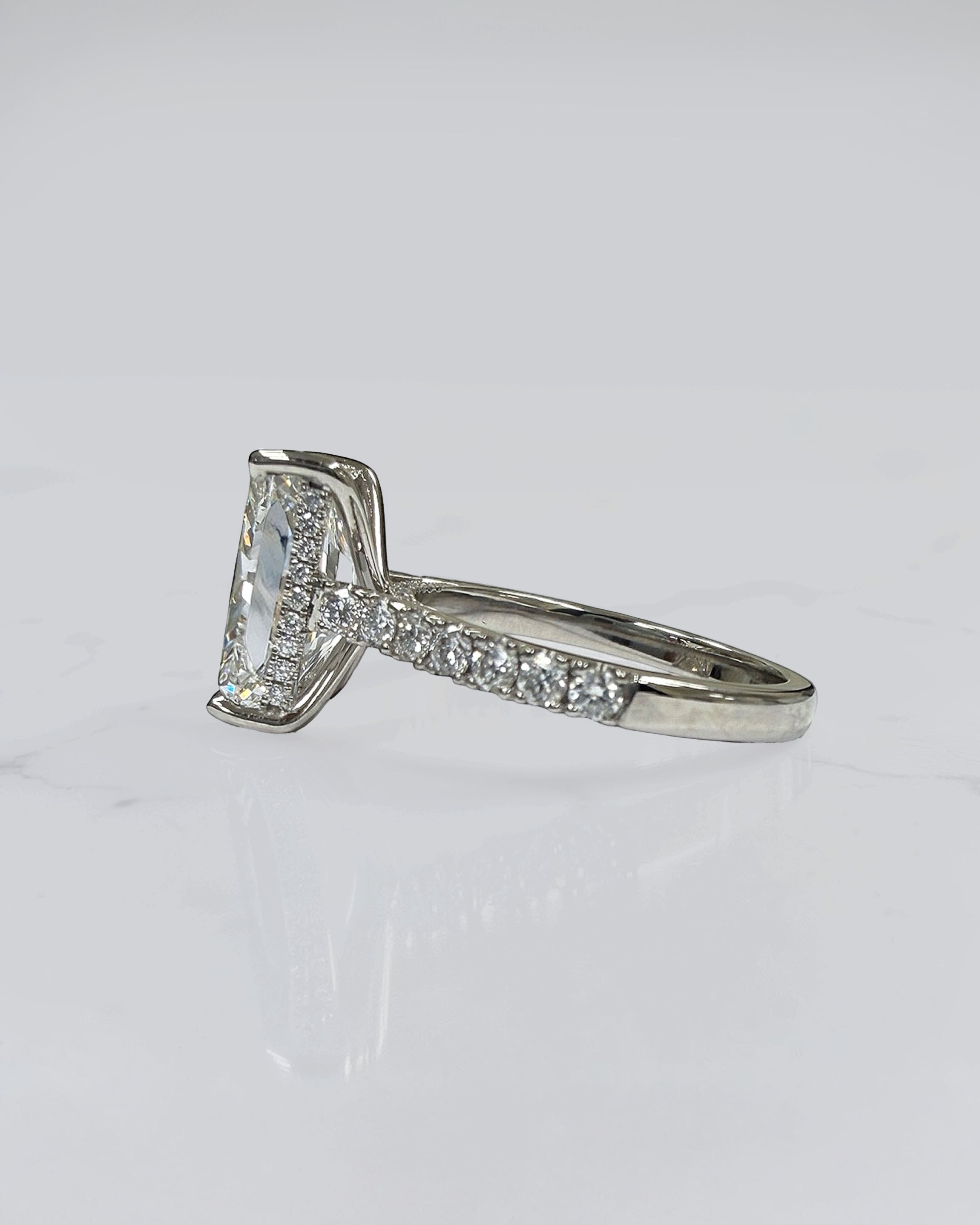 4ct radiant cut lab grown diamond engagement ring with cathedral setting, hidden halo and diamond band. Available in platinum or 18kt yellow or white gold