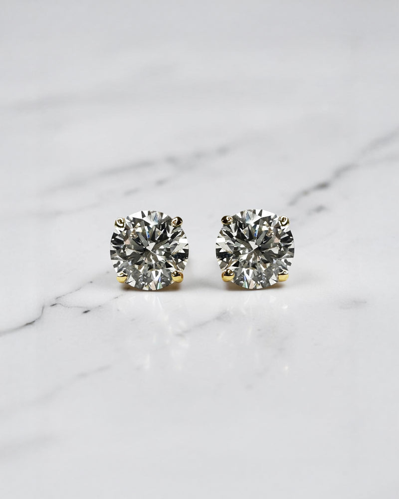 4ct round brilliant lab grown diamond stud earrings featuring 2ct E/F VS1+ lab grown diamonds with Ideal Cut, Excellent Polish, Excellent Symmetry and No Fluorescence in a four prong basket setting.