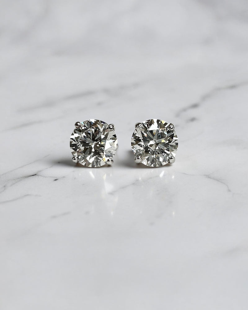 4ct round brilliant lab grown diamond stud earrings featuring 2ct E/F VS1+ lab grown diamonds with Ideal Cut, Excellent Polish, Excellent Symmetry and No Fluorescence in a four prong basket setting.