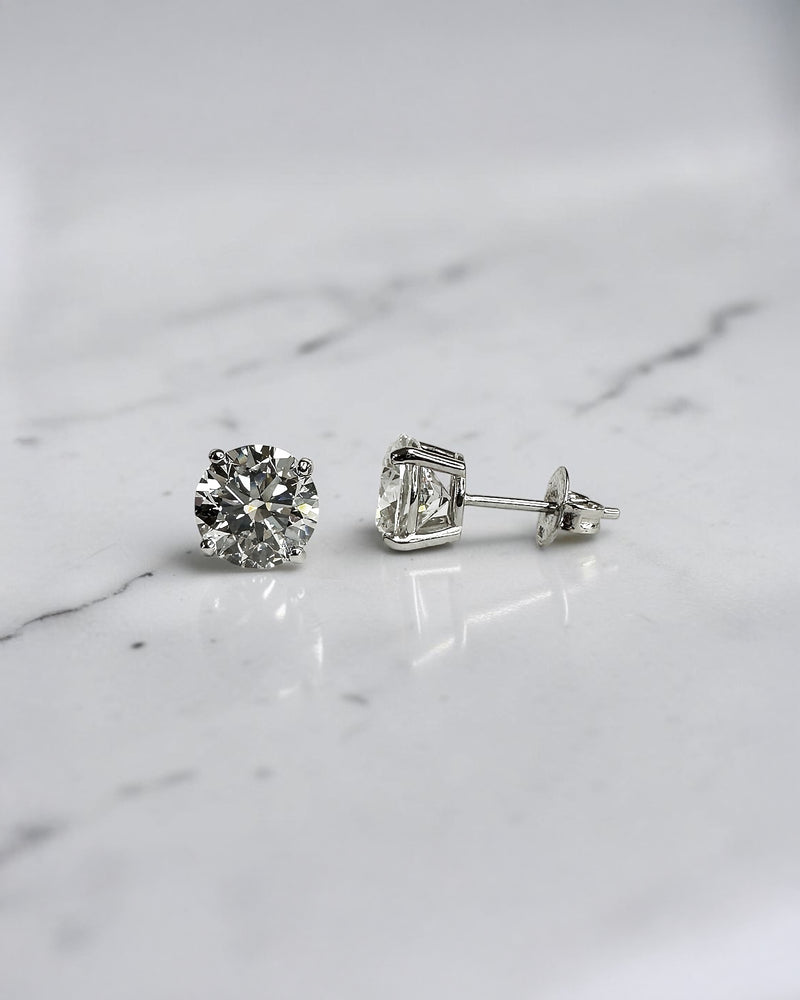 4ct round brilliant lab grown diamond stud earrings featuring 2ct E/F VS1+ lab grown diamonds with Ideal Cut, Excellent Polish, Excellent Symmetry and No Fluorescence in a four prong basket setting.